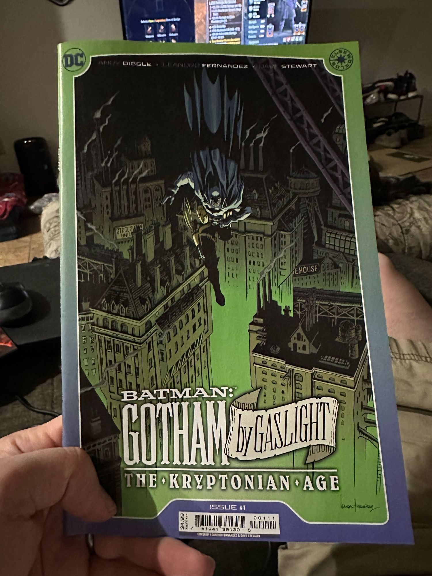 The covers of Gotham by Gaslight: The Kryptonian Age #1, a green-tinged drawing of Batman leaping toward the reader above a Gilded Age Gotham filled with smokestacks, the title is at the bottom.