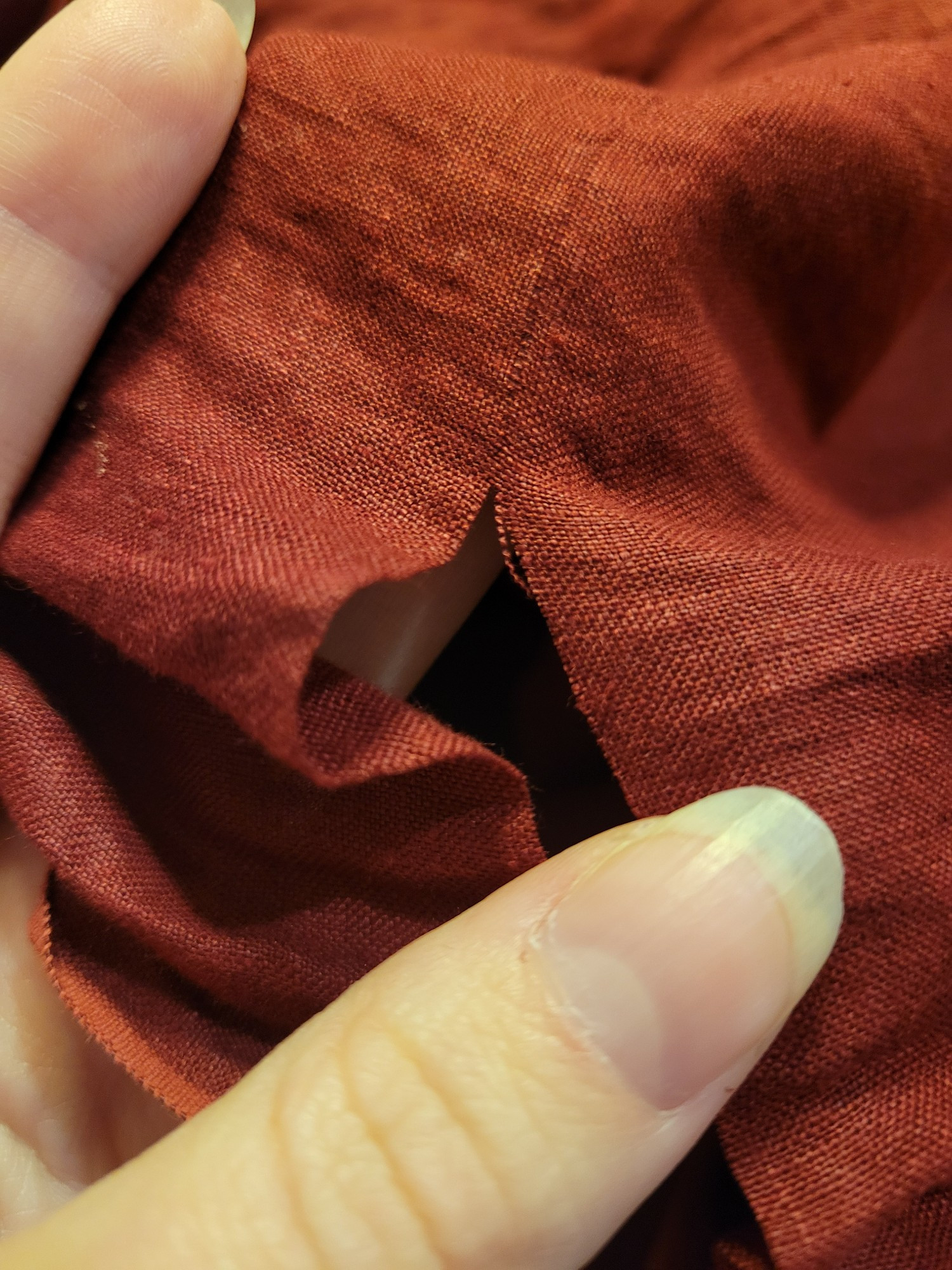 Red linen cut along the drawn thread.