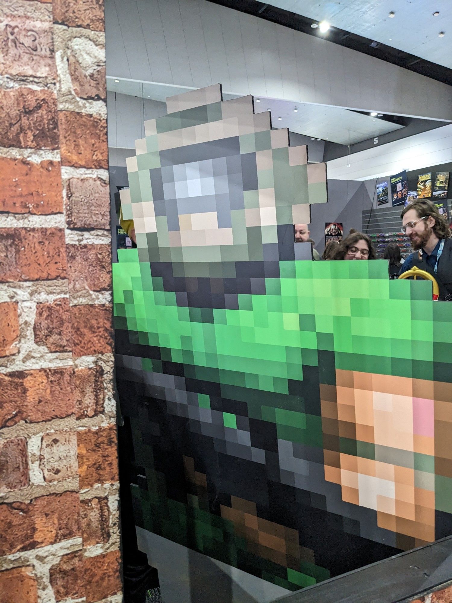 A large cardboard cutout of Doomguy (circa 1994) looking menacingly through a window.