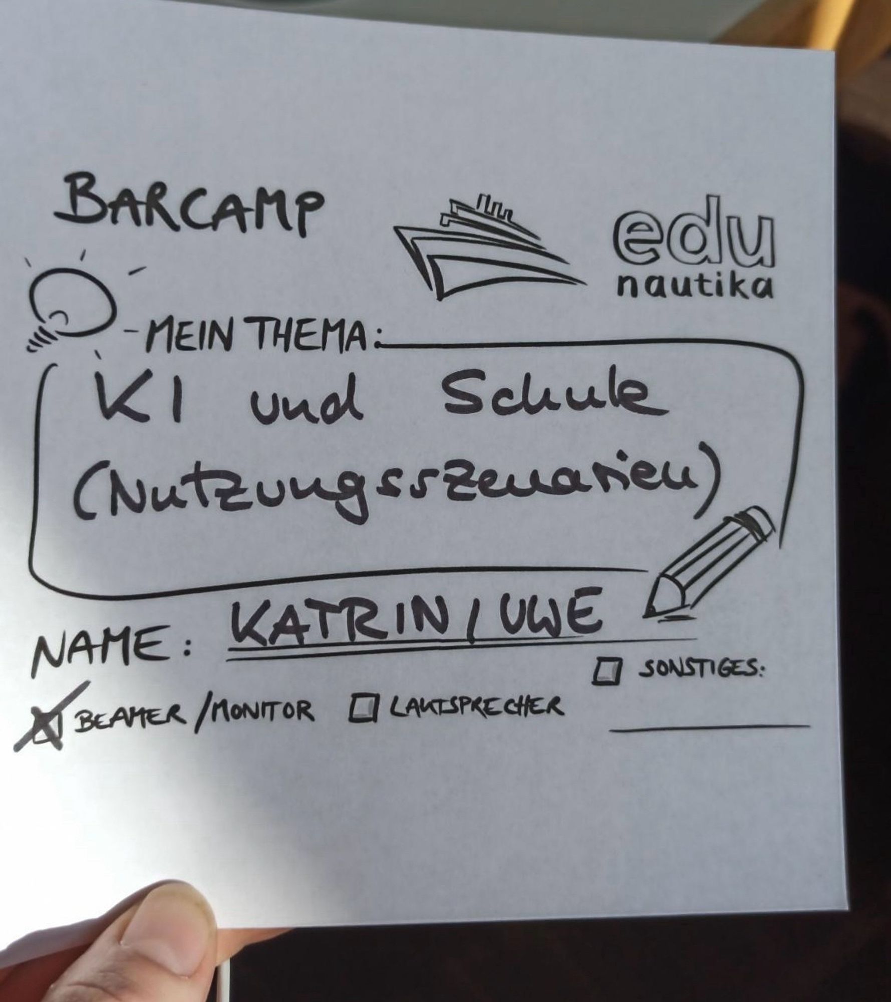 Ein Zettel auf dem das Thema für eine Session beim BarCamp Edunautika steht. Das Thema lautet KI und Schule (Nutzungsszenarien in MV) von Katrin und Uwe.