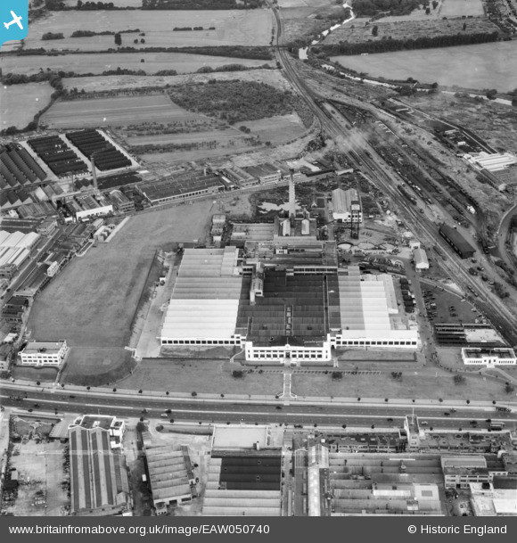 An aerial view of the long-demolished Art Deco Firestone factory in Hounslow, London, in 1953. It is surrounded by a mix of fields, railway lines, roads and industrial sheds.