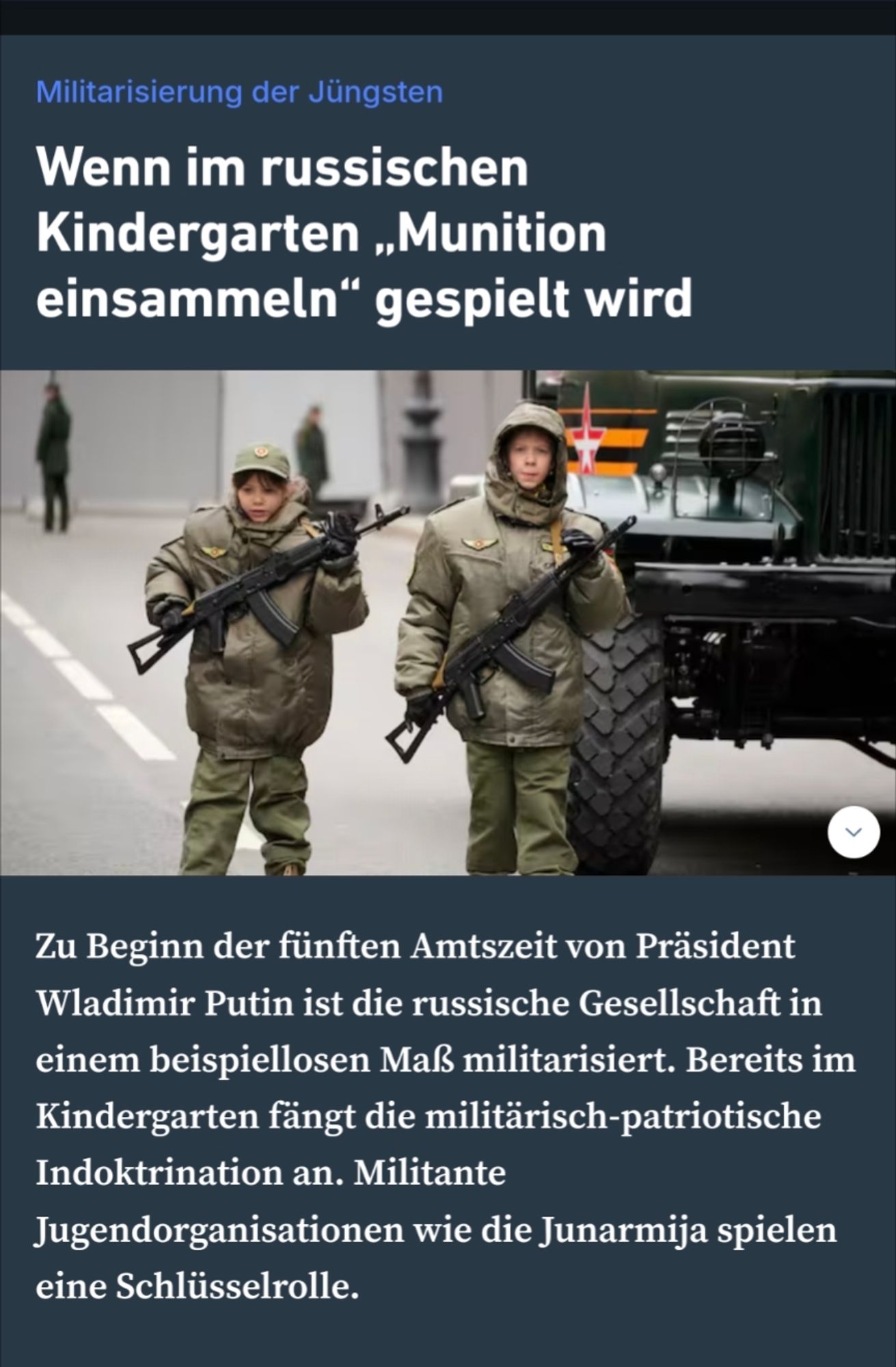 Zwei Jugendliche vor einem Militärfahrzeug in Khaki-Winterjacken und jeder ein Gewehr vor der Brust umgehängt.