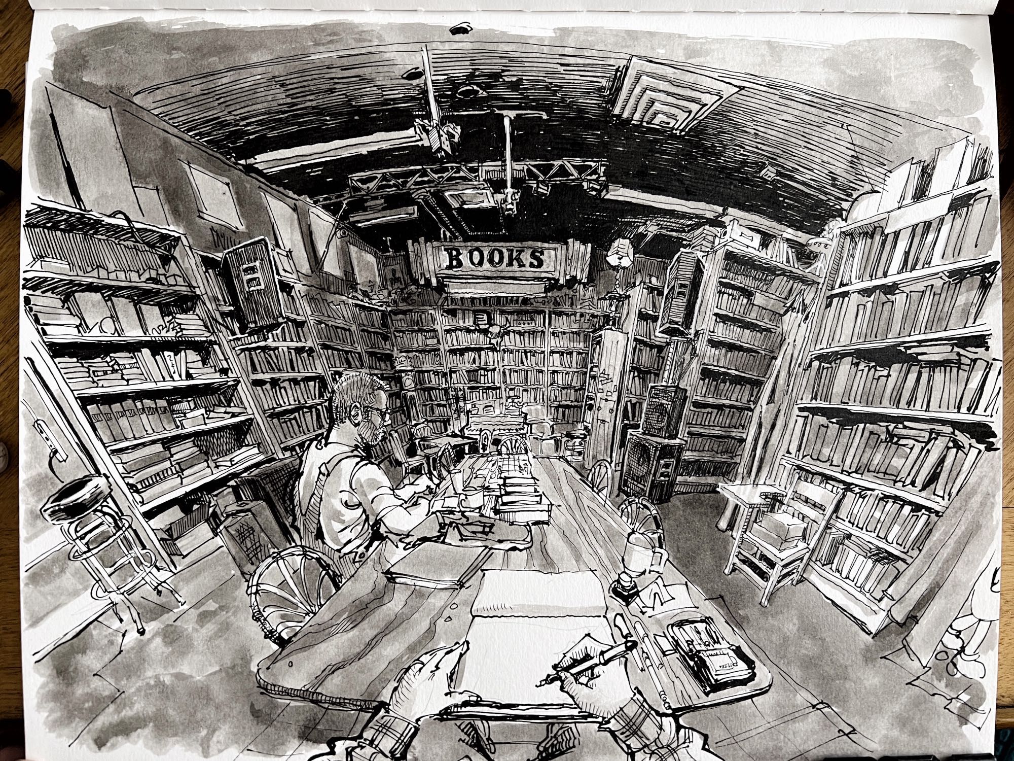 Pen and ink black and white drawing of a wide angle view of a dark bookstore interior.