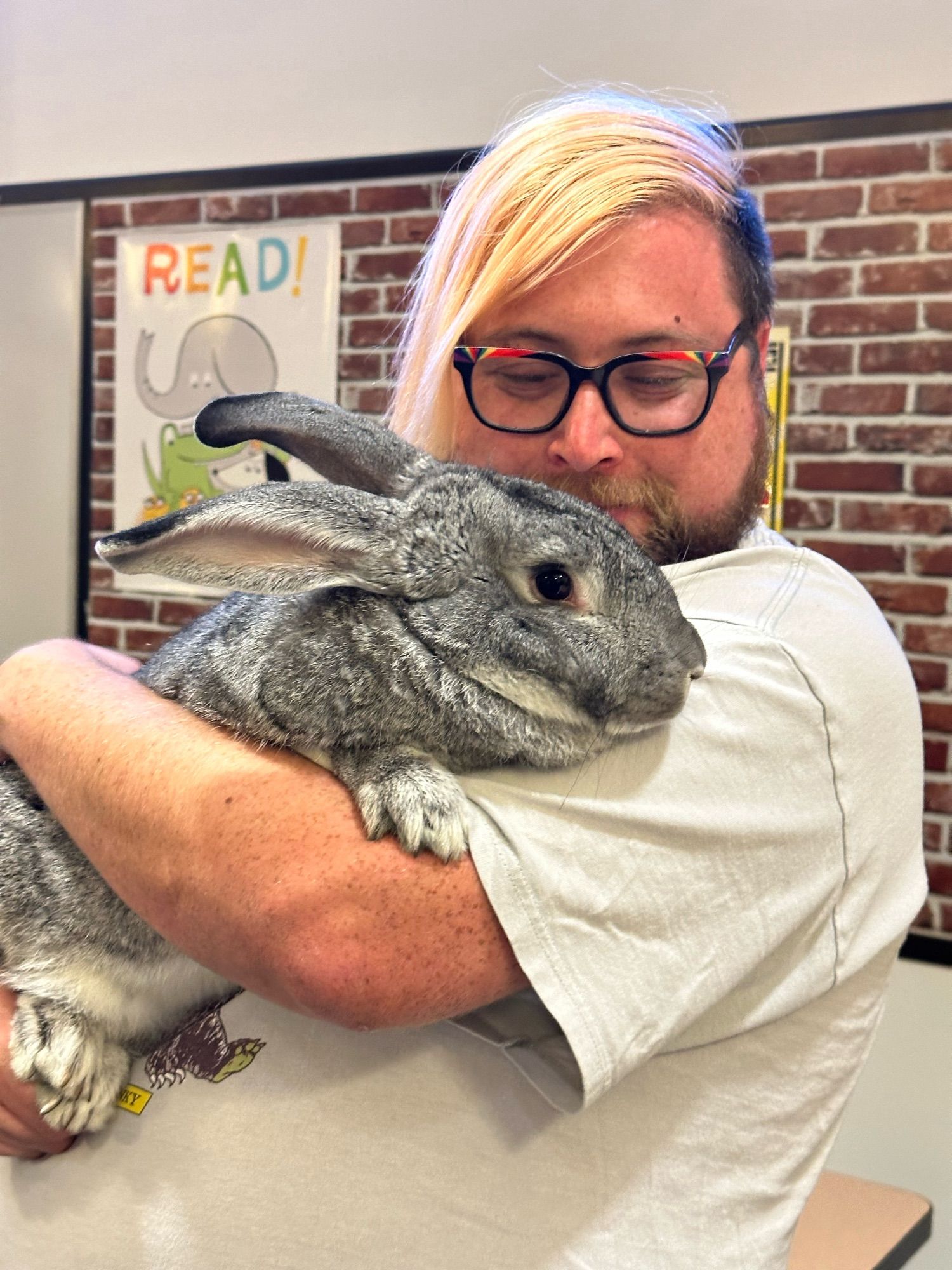 Vincey, looking proudly at the rabbit as they cradle it in their arms.