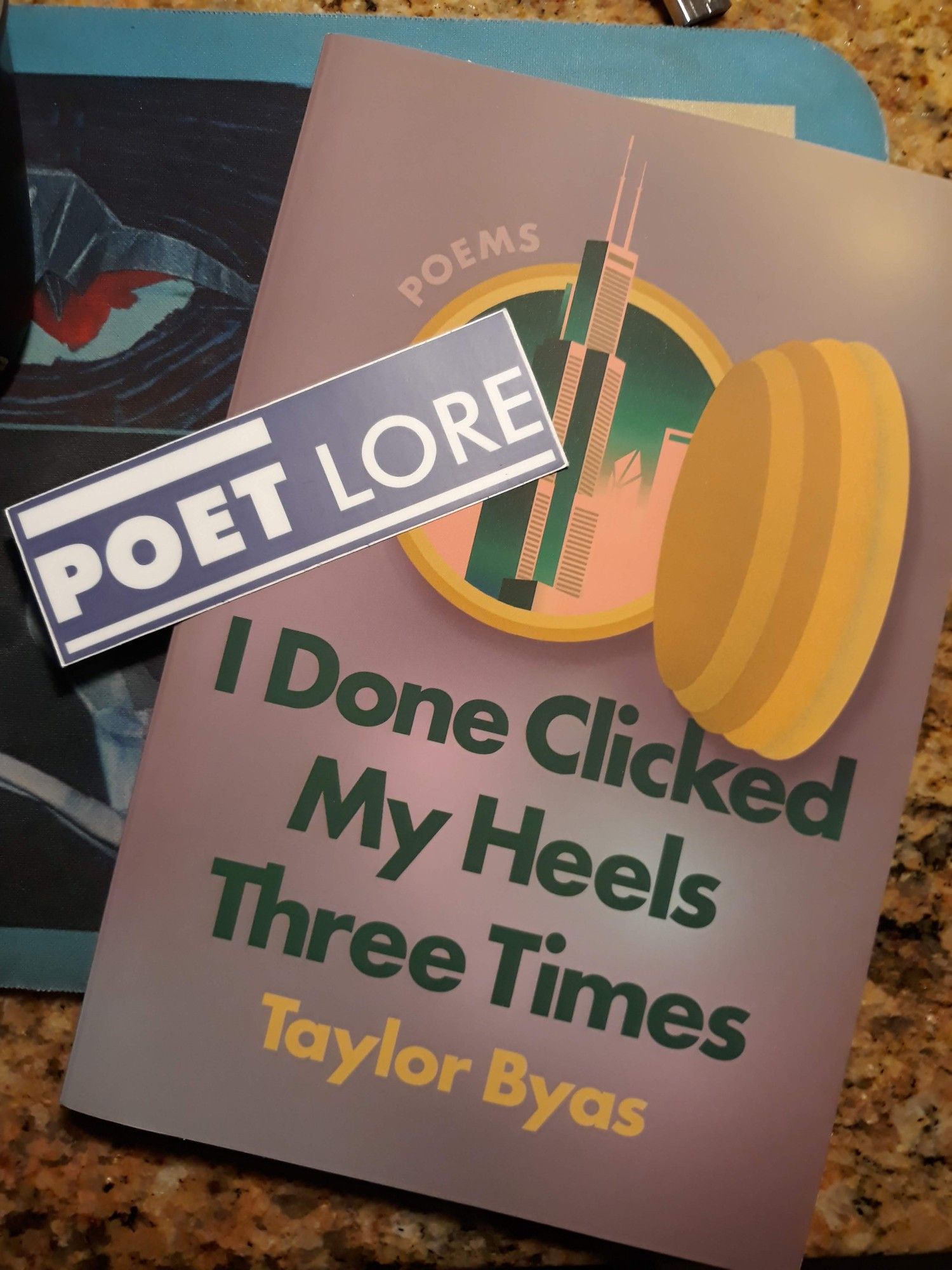 Cover of I Done Clicked My Heels Three Times and a Poet Lore sticker on it: Chicago skyline through an open bull's eye (?). Color scheme is green, yellow, and pink on a ground that mixes the three colors, resulting in an uneven tannish shade.