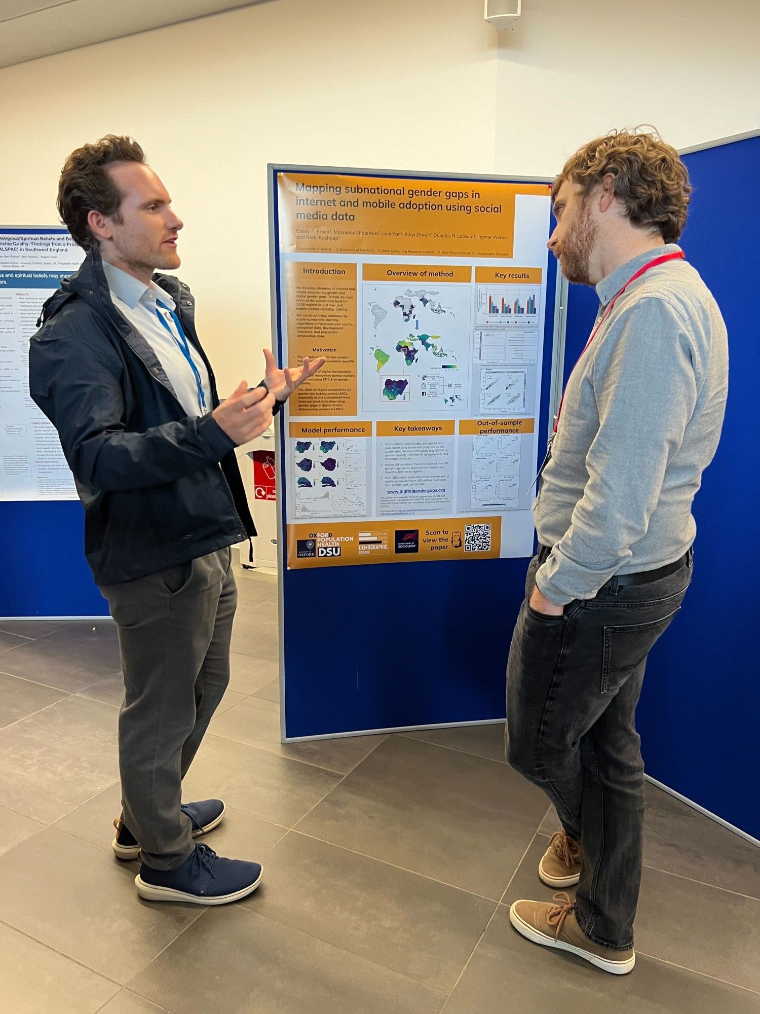 Casey in conversation in front of his poster at BSPS 2024