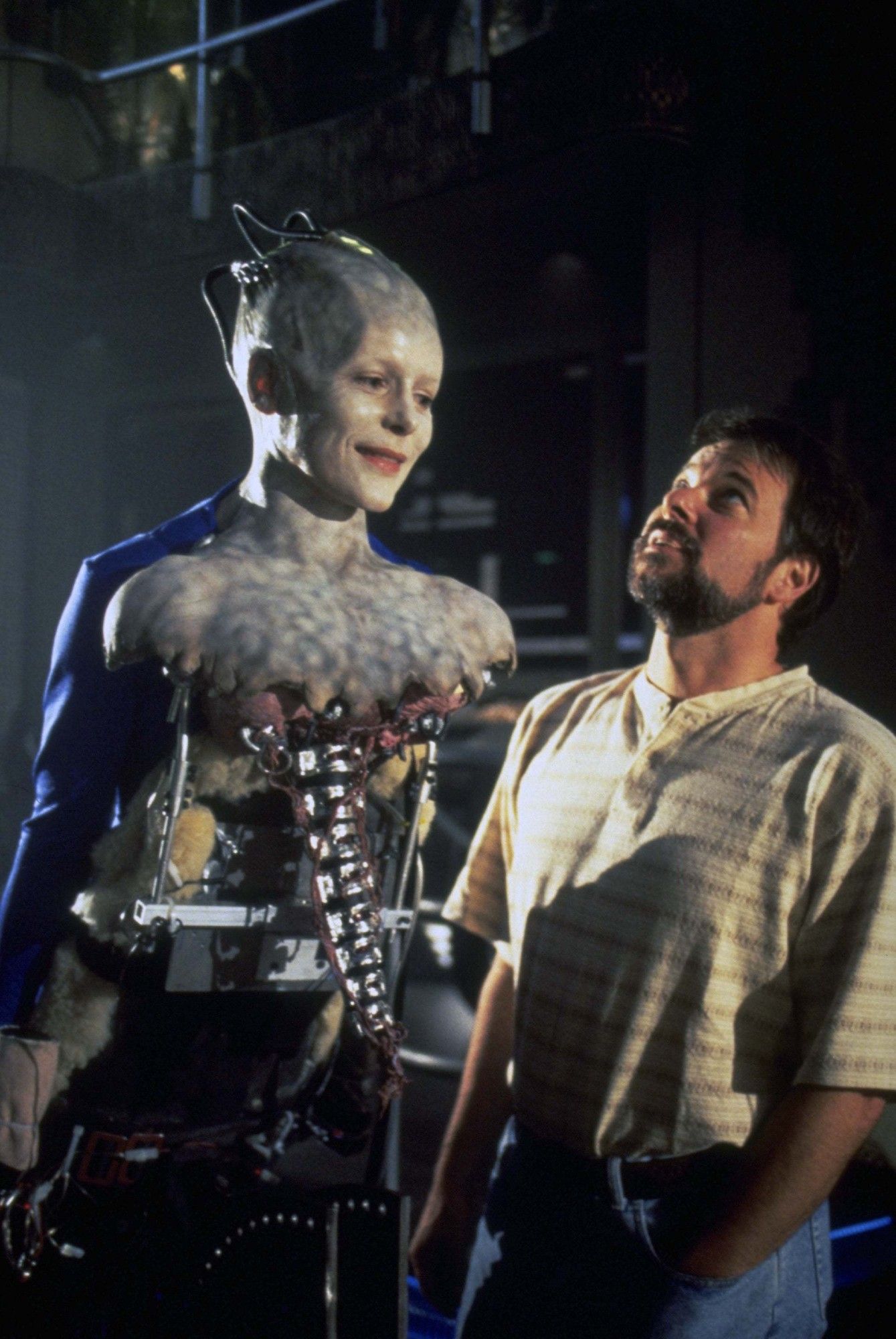 Frakes looking up at the rigging as Alice Krige smiles.