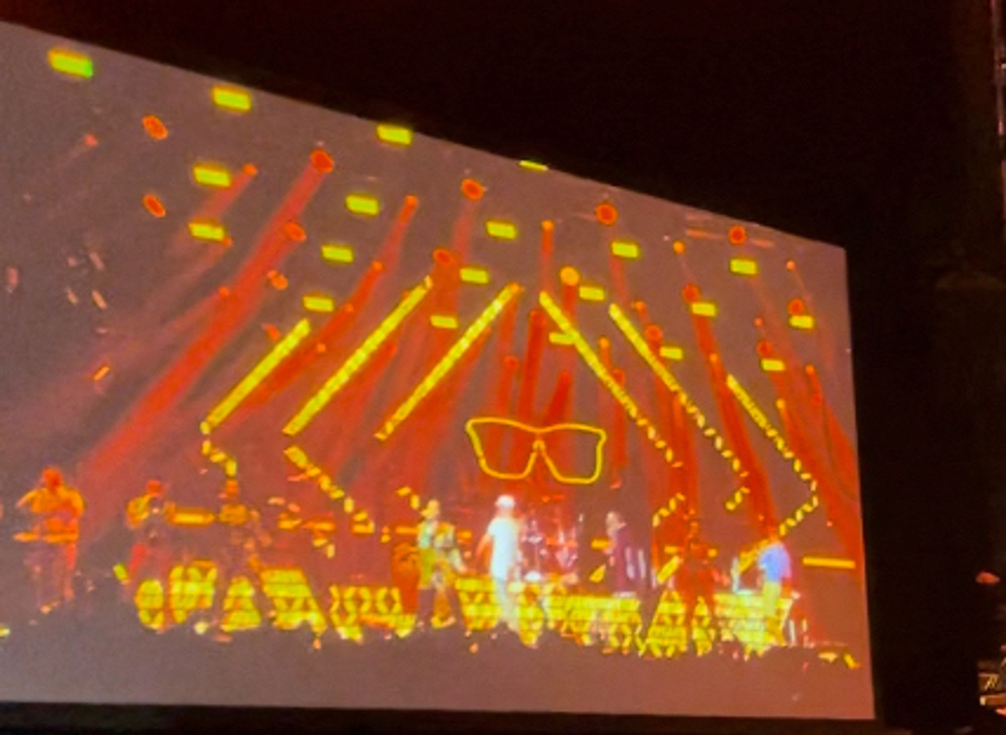 Bunte Lichtershow beim Konzert von Jan Delay in gelb-rot. In der Mitter Bühne ist eine große gelbe Sonnenbrille projeziert.