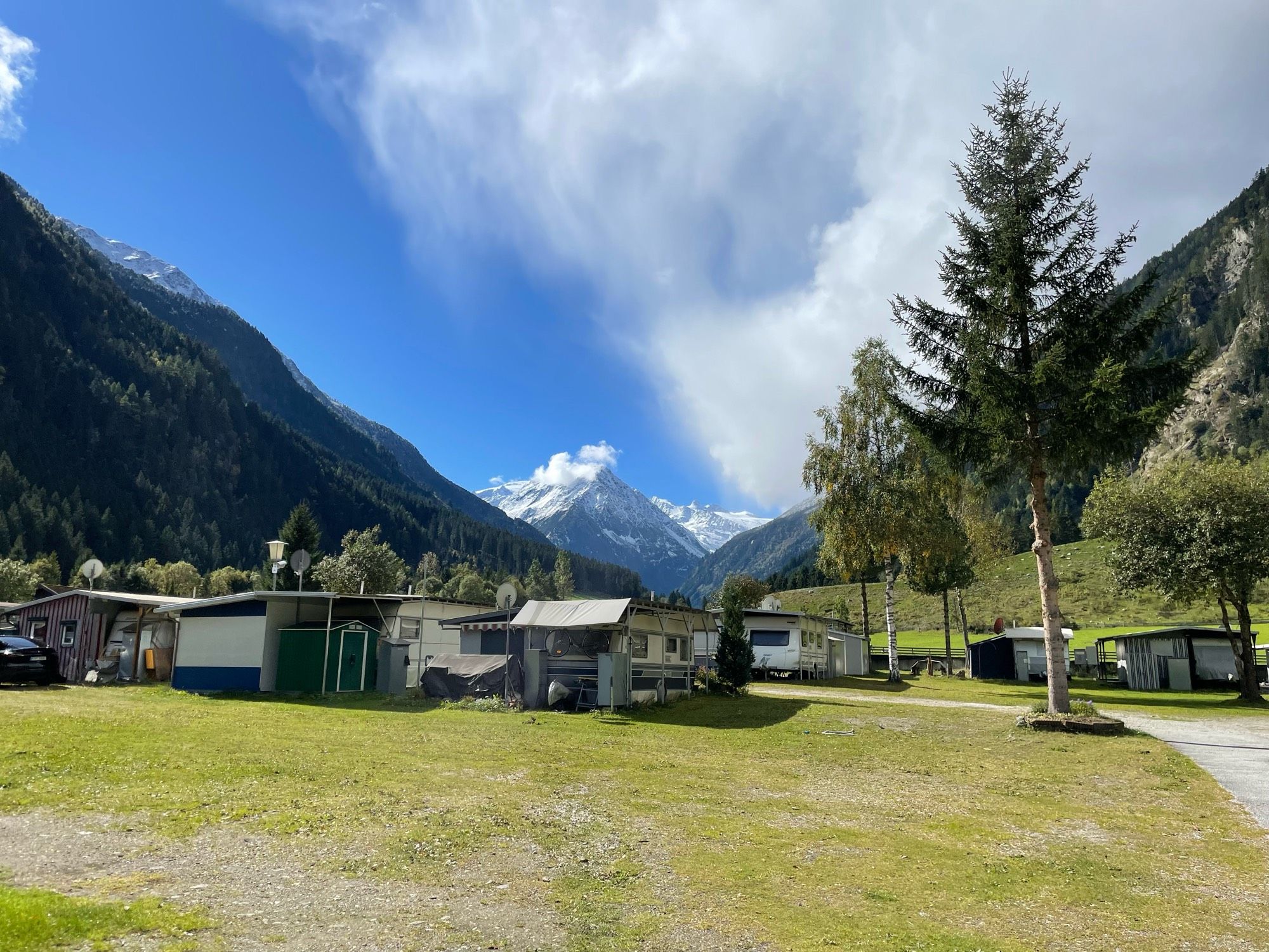 Blick von einem Campingplatz Richtung verschneiter Berge