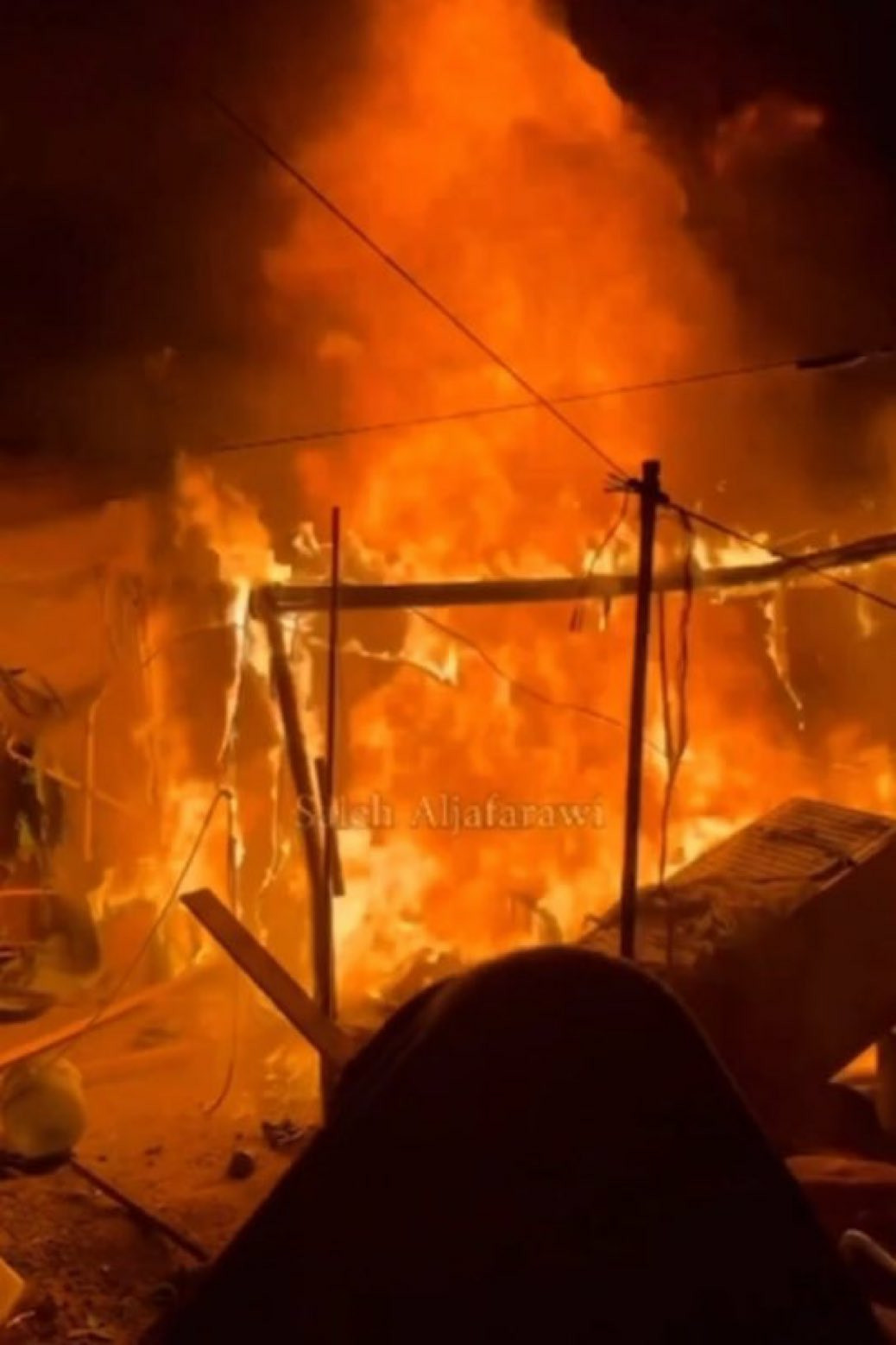 The frame of a tent in a refugee camp in Northern Gaza, engulfed in flames