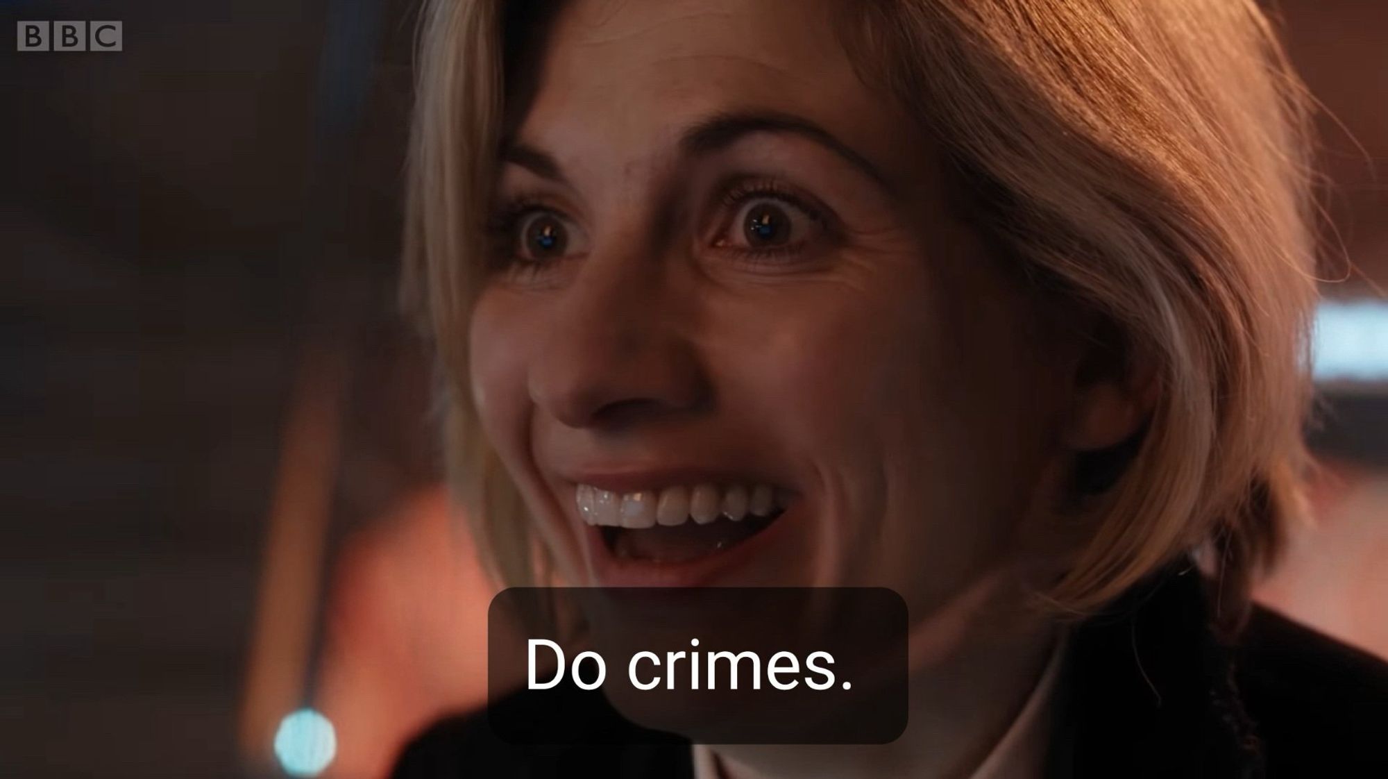 Jodie Whittaker, la 13eme Doctor avec un grand sourire sur le visage, et le sous-titre “do crimes”