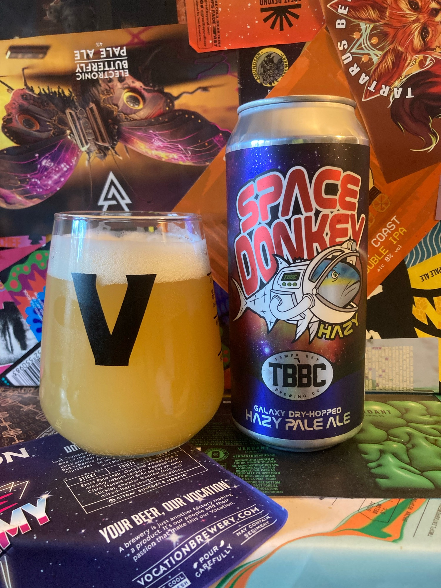 A can of Space Donkey, a 5.5% hazy pale ale, to the right of a glass of the same. The can features a fish in a space suit. For some reason.