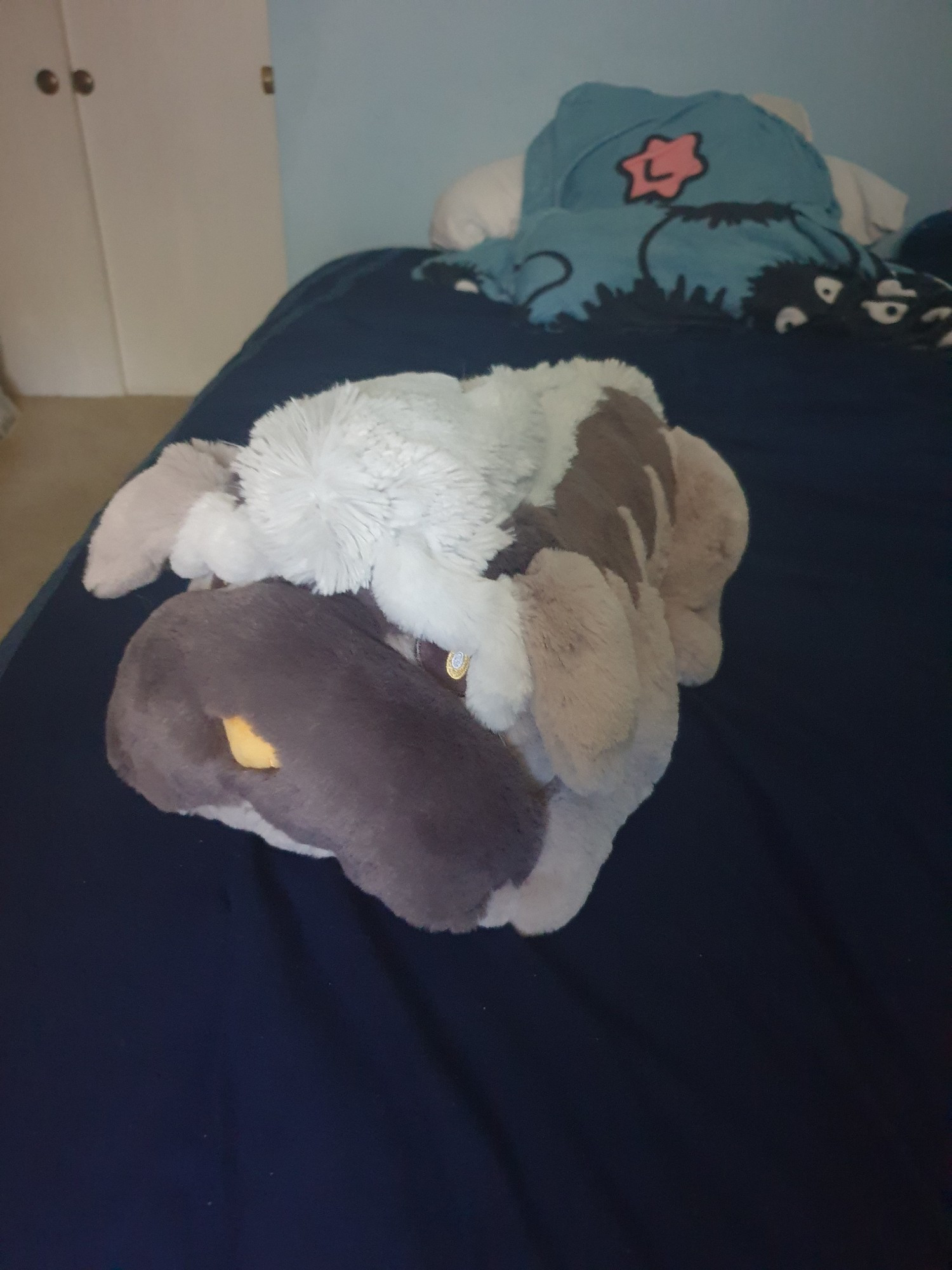 Plush of the Pokemon Mabosstiff sitting upon my bed looking real cute and comfy.