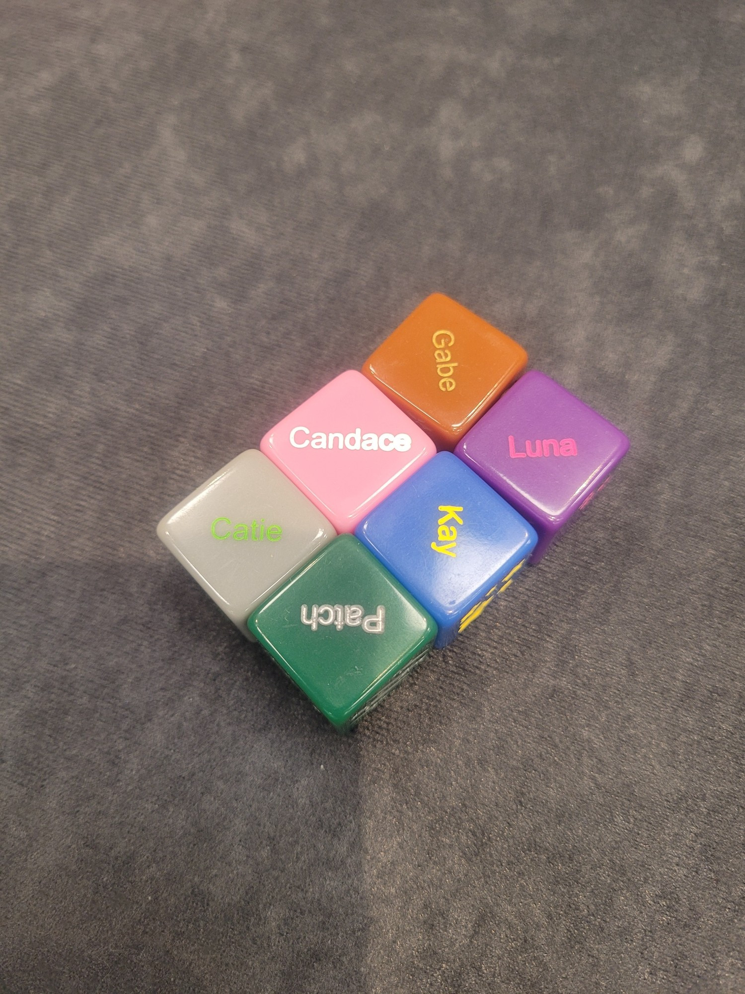 A set if dice that read "Gabe", "Luna", "Candace", "Kay", "Catie", and "Patch"