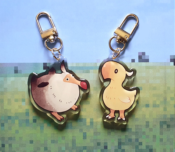 A photo of two acrylic keychains: the fledgling dodo and chocobo chick from the Final Fantasy series.