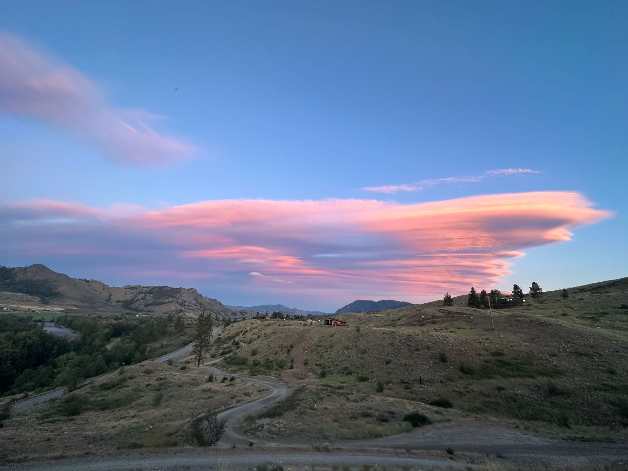 Clouds lit by a setting sun over mountains 