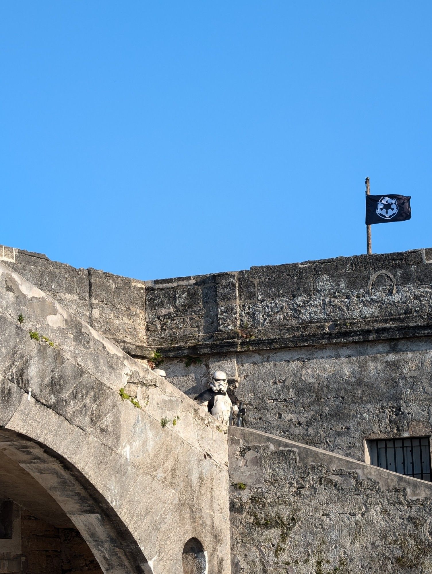 Picture of a sandtrooper on a staircase inside the Castillo de San Marcos in St Augustine, Florida after the Empire's successful invasion.  The Empire flag flying high to let citizens know that the facility is secured and they are now under the protection of the Empire.