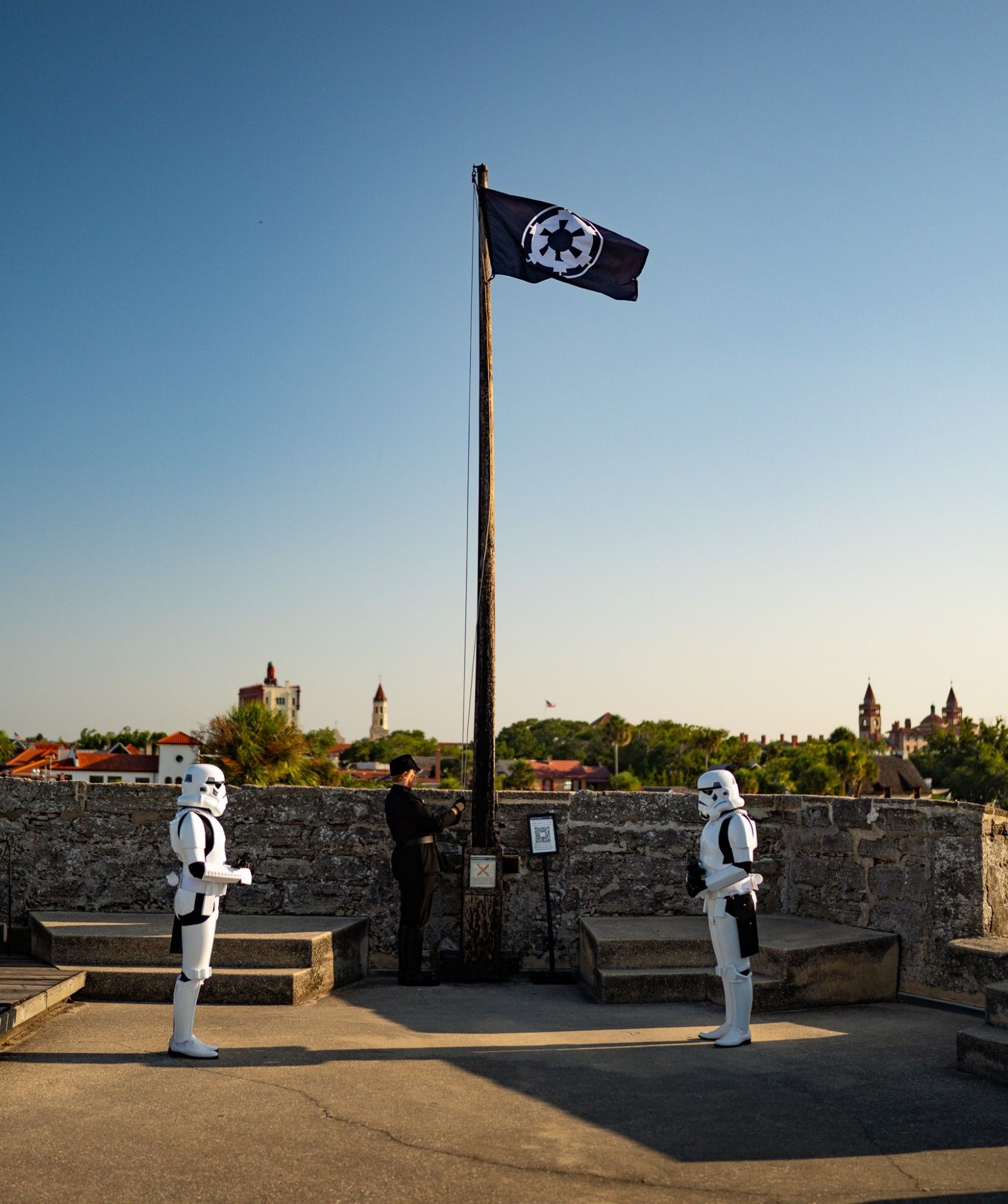 501stlegion Florida Garrison Imperial invasion of the Castillo de San Marcos in St Augustine, FL on August 17, 2024.  This is a picture of the ranking officer raising the Imperial flag on top of the fortress with two stormtroopers standing at attention.