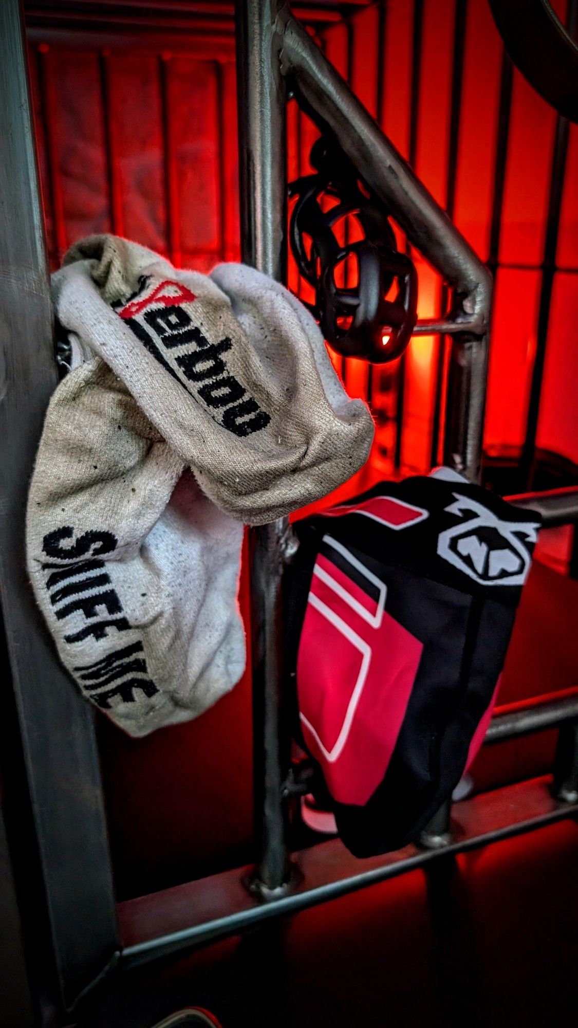 Dirty socks, chastity cage and jockstrap placed in a cage door