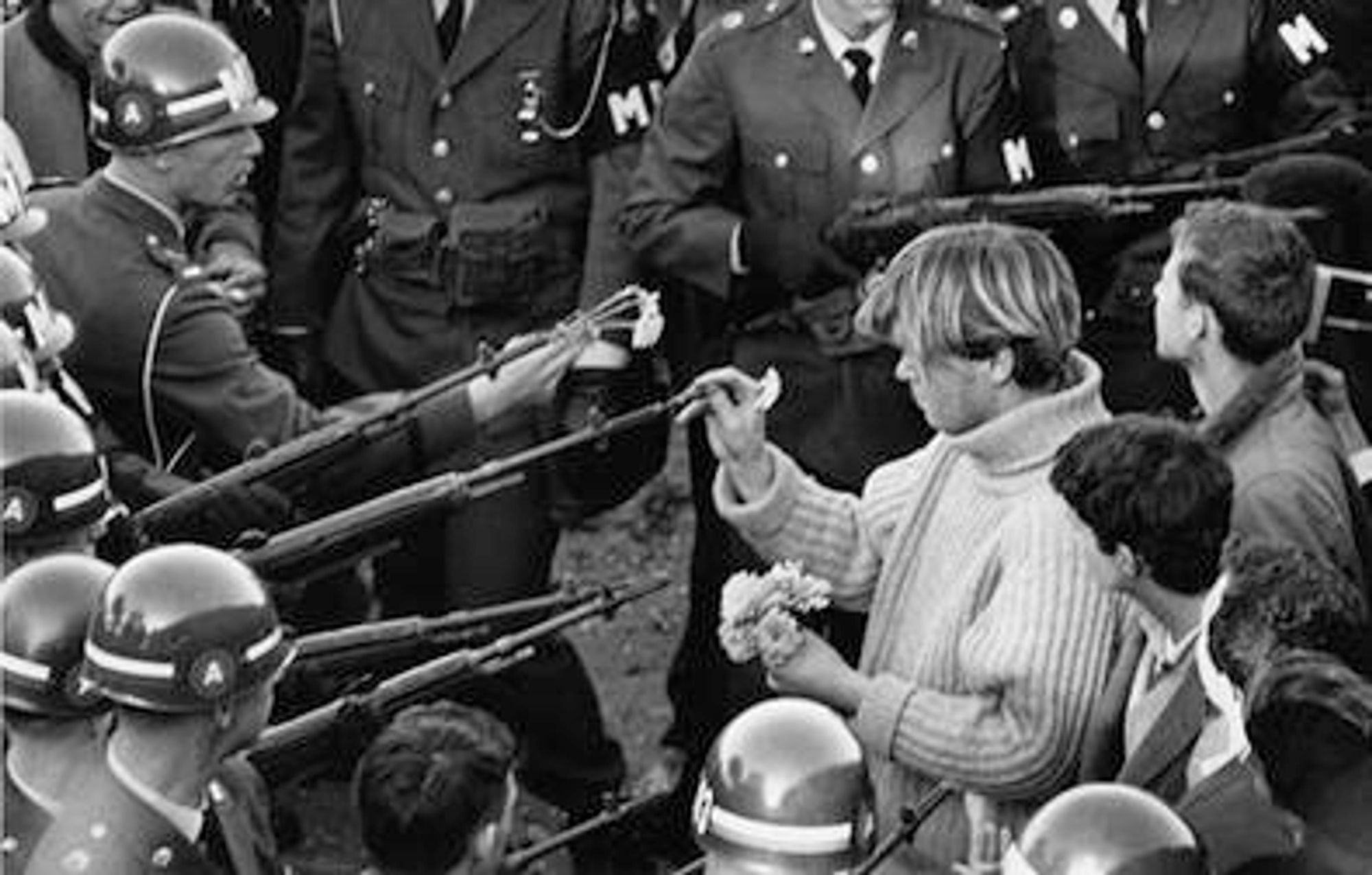 Flower Power is the title of a photograph taken by American photographer Bernie Boston for the now-defunct newspaper The Washington Evening Star. Taken on October 21, 1967, during the March on the Pentagon by the National Mobilization Committee to End the War in Vietnam, the photo shows protester George Harris placing a carnation into the barrel of an M14 rifle held by a soldier of the 503rd Military Police Battalion (Airborne).
 -quoted from Wikipedia