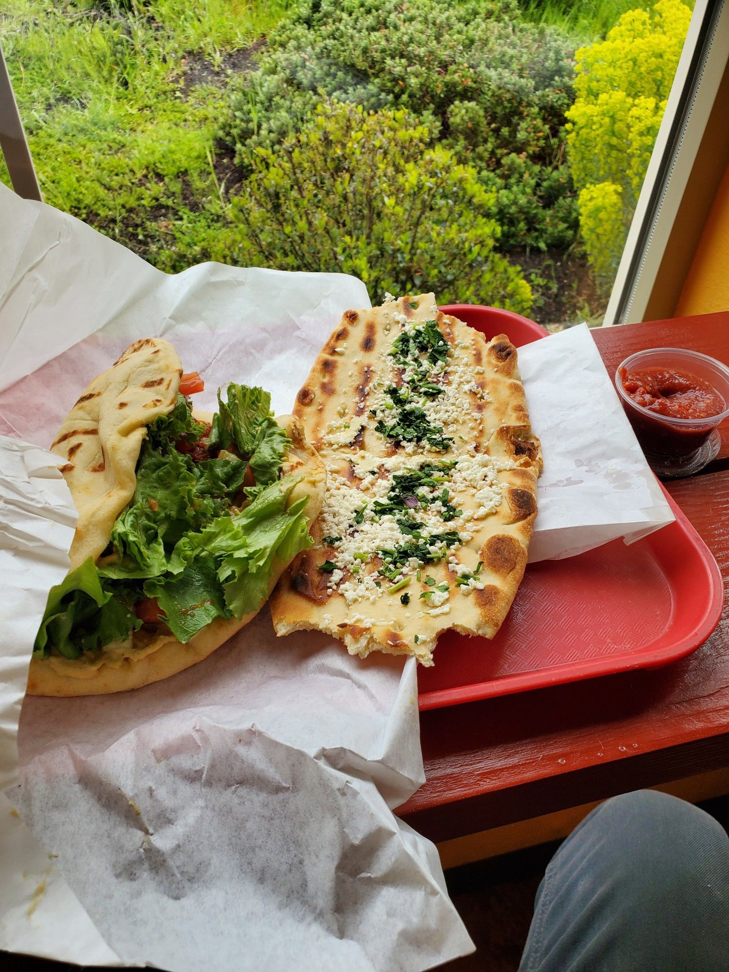 Bombass falafel gyro and a fresh hot slice of garlic Naan bread with feta and green onions