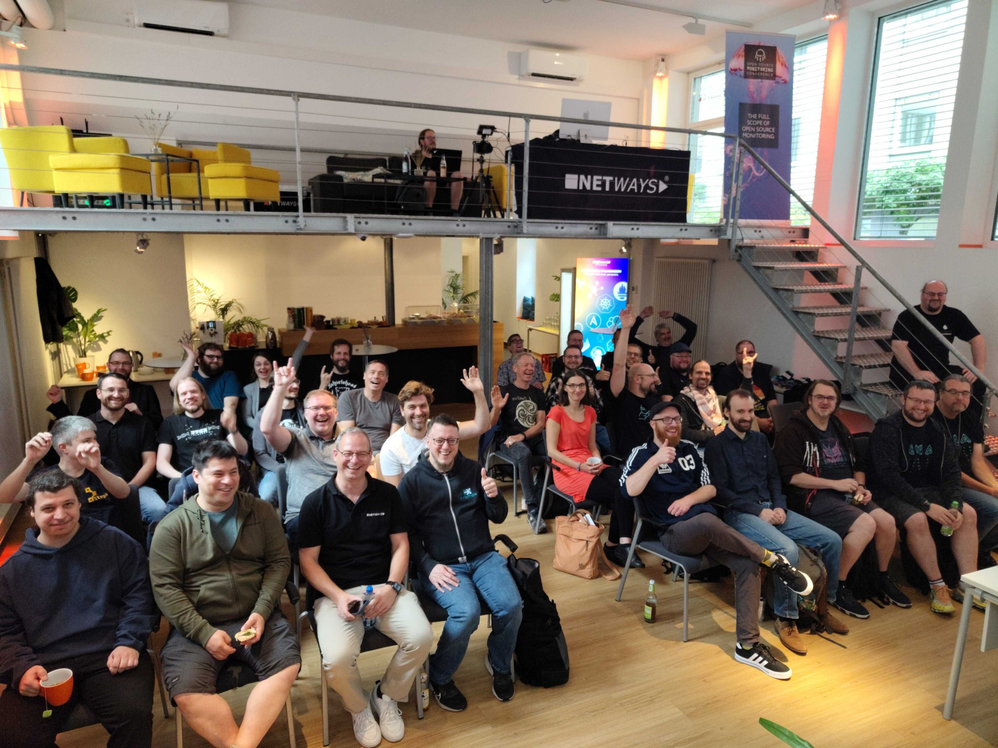 A room full of happy Vox Pupuli contributors. One is sitting on the stairs.
