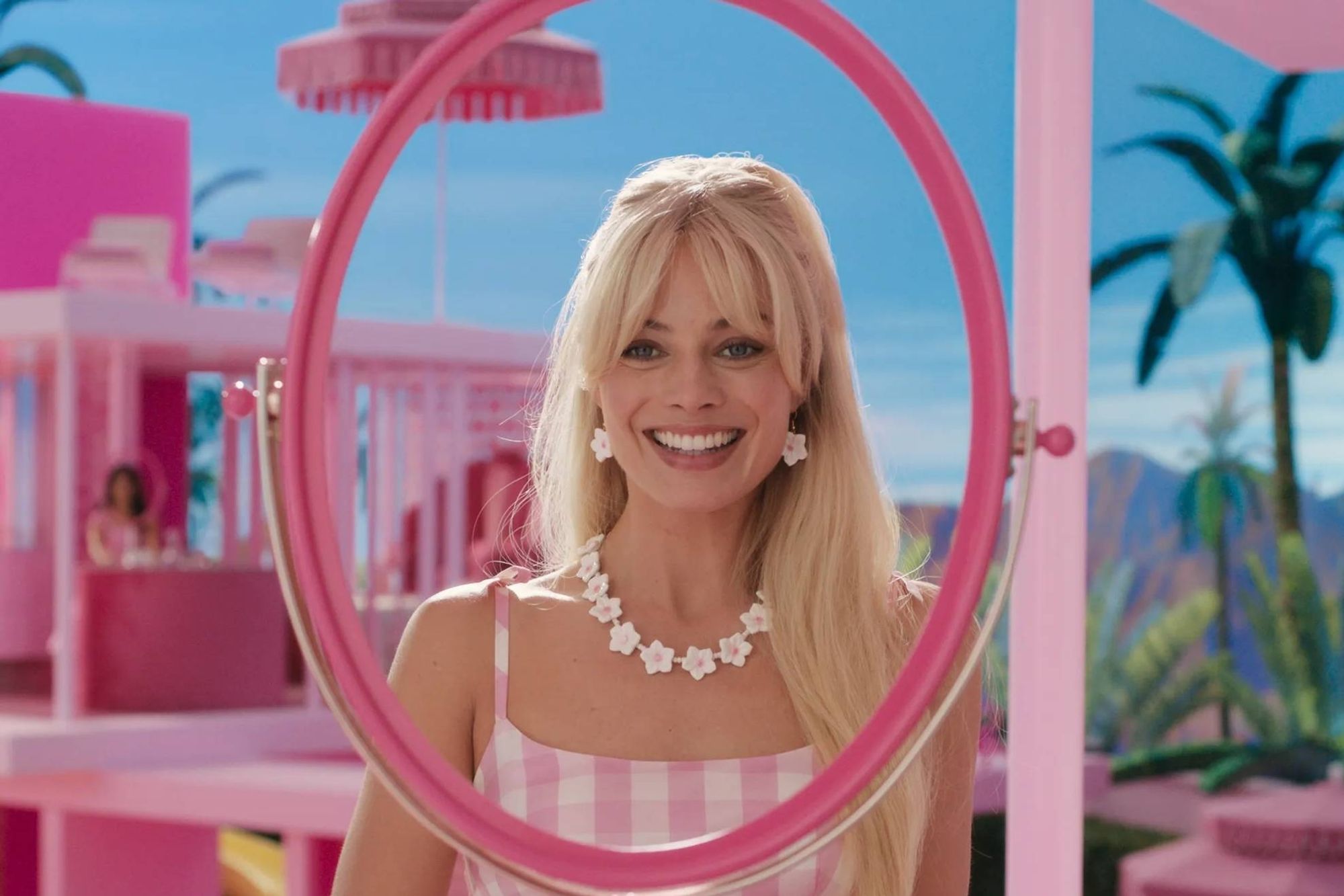 Photo of Margot Robbie in the Barbie movie, looking into a mirror without glass.