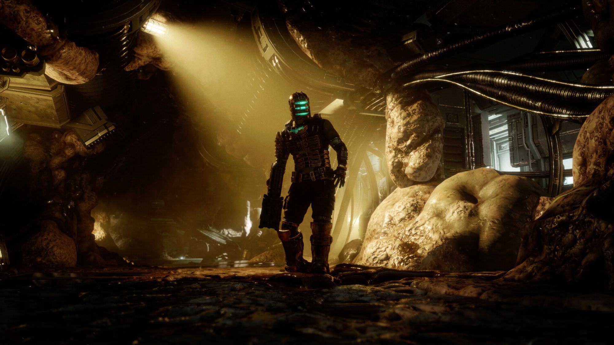 A screenshot from Dead Space. Isaac Clarke, in a sci-fi suit, stands in a darkly lit room.