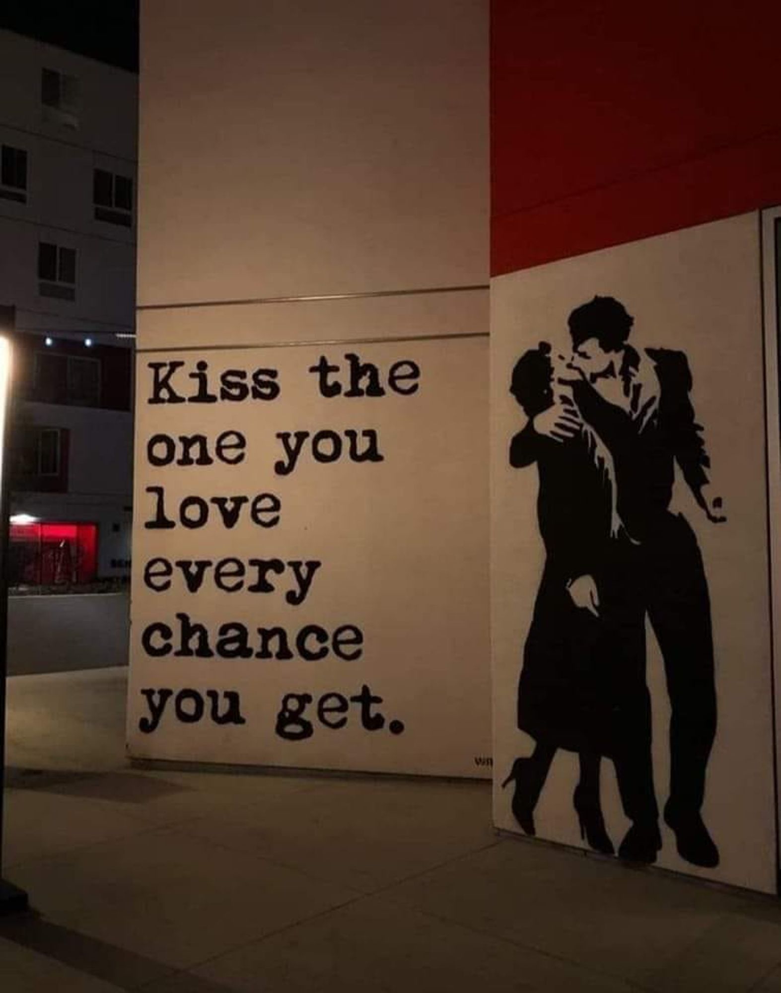 Street Art : un couple s'embrasse, on peut lire à côté : 
« Kiss the one you love every chance you get. »