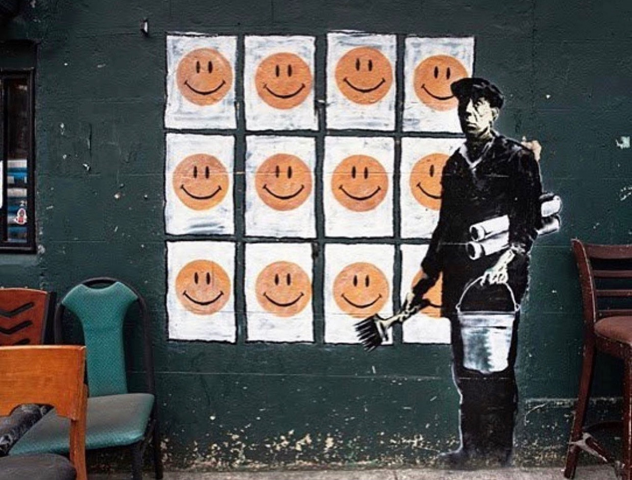 Strret Art : un homme peint a collé des lignes des smiley *sourire* façon morpions.