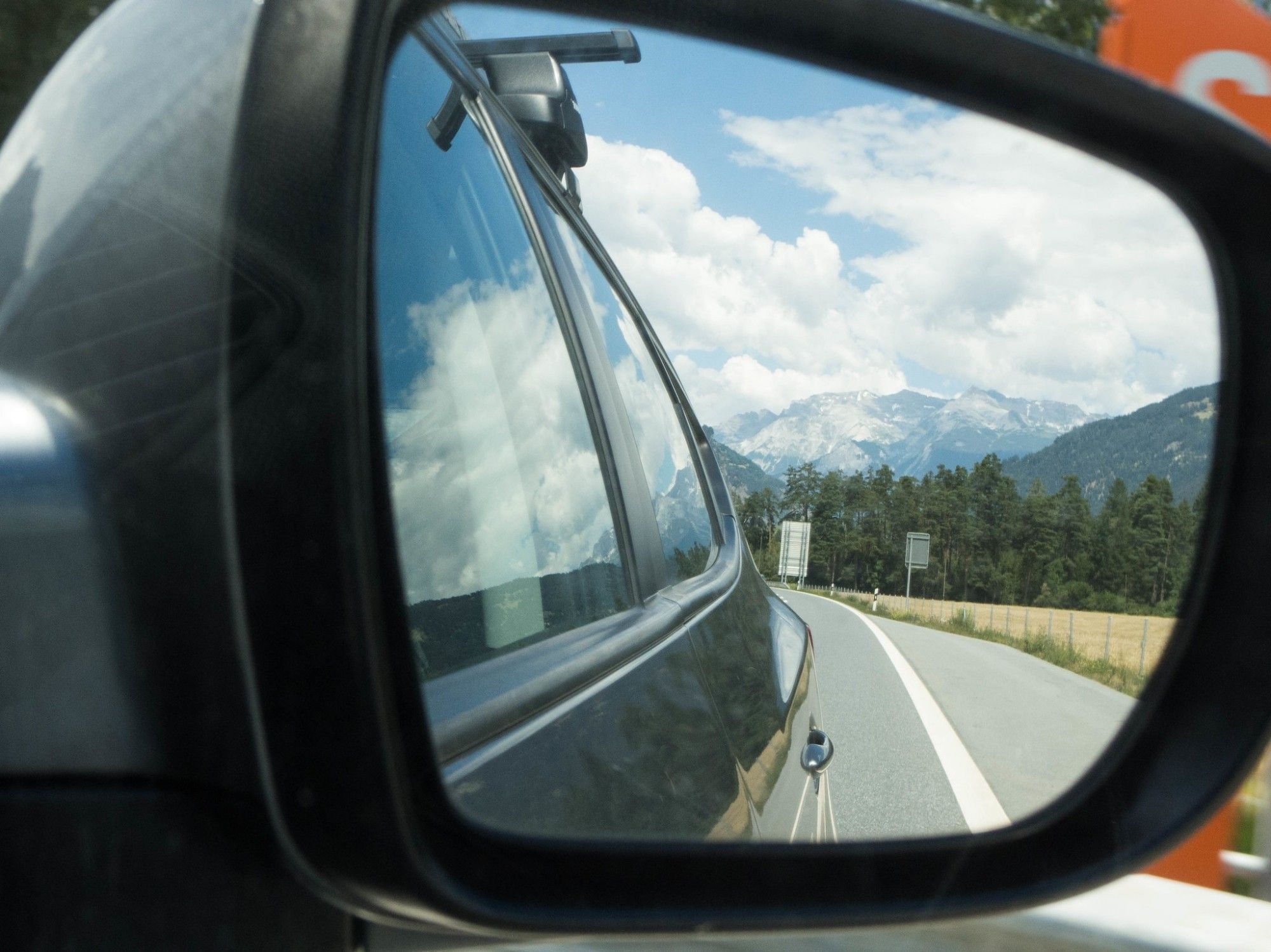 Berge spiegeln sich im Rückspiegel eines Autos