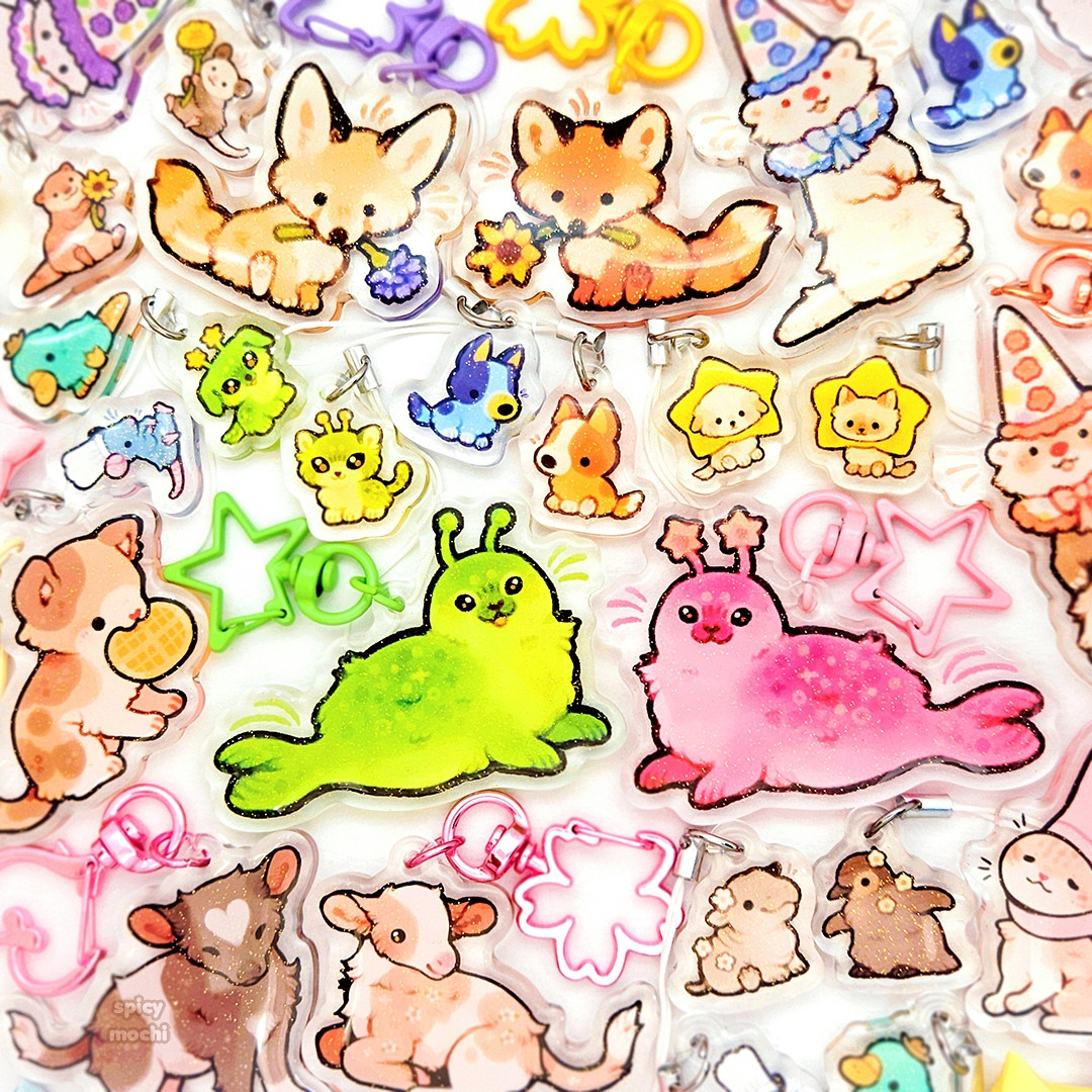 colorful keychains of little animal friends, including cats, dogs, alien seals, foxes holding flowers, fluffy cows, and clown ferrets