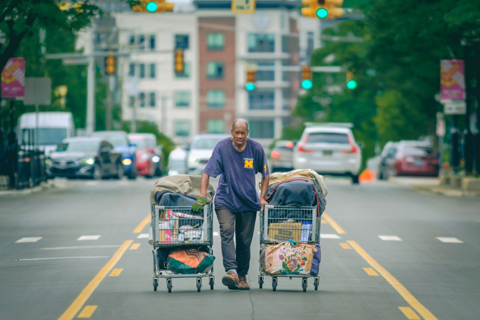 Posted previously as "TWENTYTWENTYTHREE" (I can't remember if it was on Twitter, now deleted).  It's a Homeless dude with a shopping cart full of stuff under each arm.  He's hustling down the middle lane of a busy downtown street.  Cars and big highrises blot out the sky behind him.  300mm canon FD (vintaaaage) f2.8