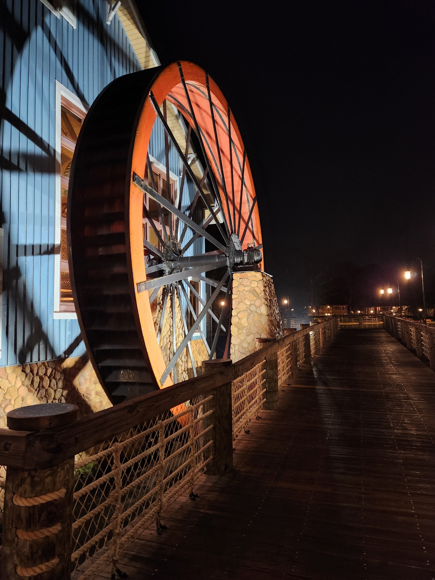 Water wheel at Port Orleans Riverside. Taken early in the morning. Wheel is lit and red interior. Building behind is blue.