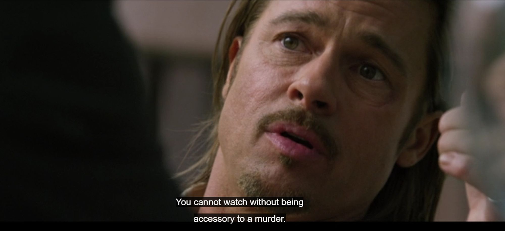 a closeup of Brad Pitt speaking. The caption reads 'You cannot watch without being accessory to a murder' (from The Counselor)