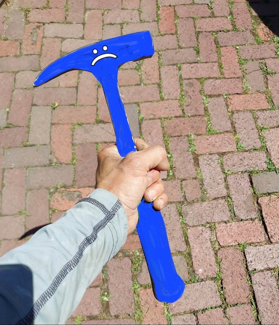 A gigantic hammer with herringbone brick in the background. Hammer is BSOD, colored in blue and has frowny face.