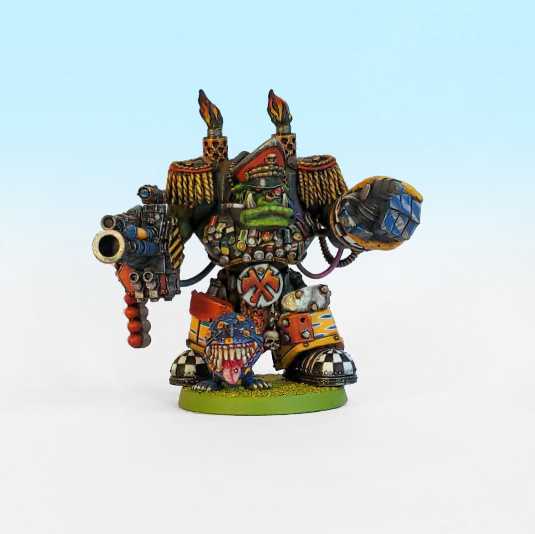 A model of a blood axe space ork warboss in mega armour with a peaked cap and oversized epaulettes