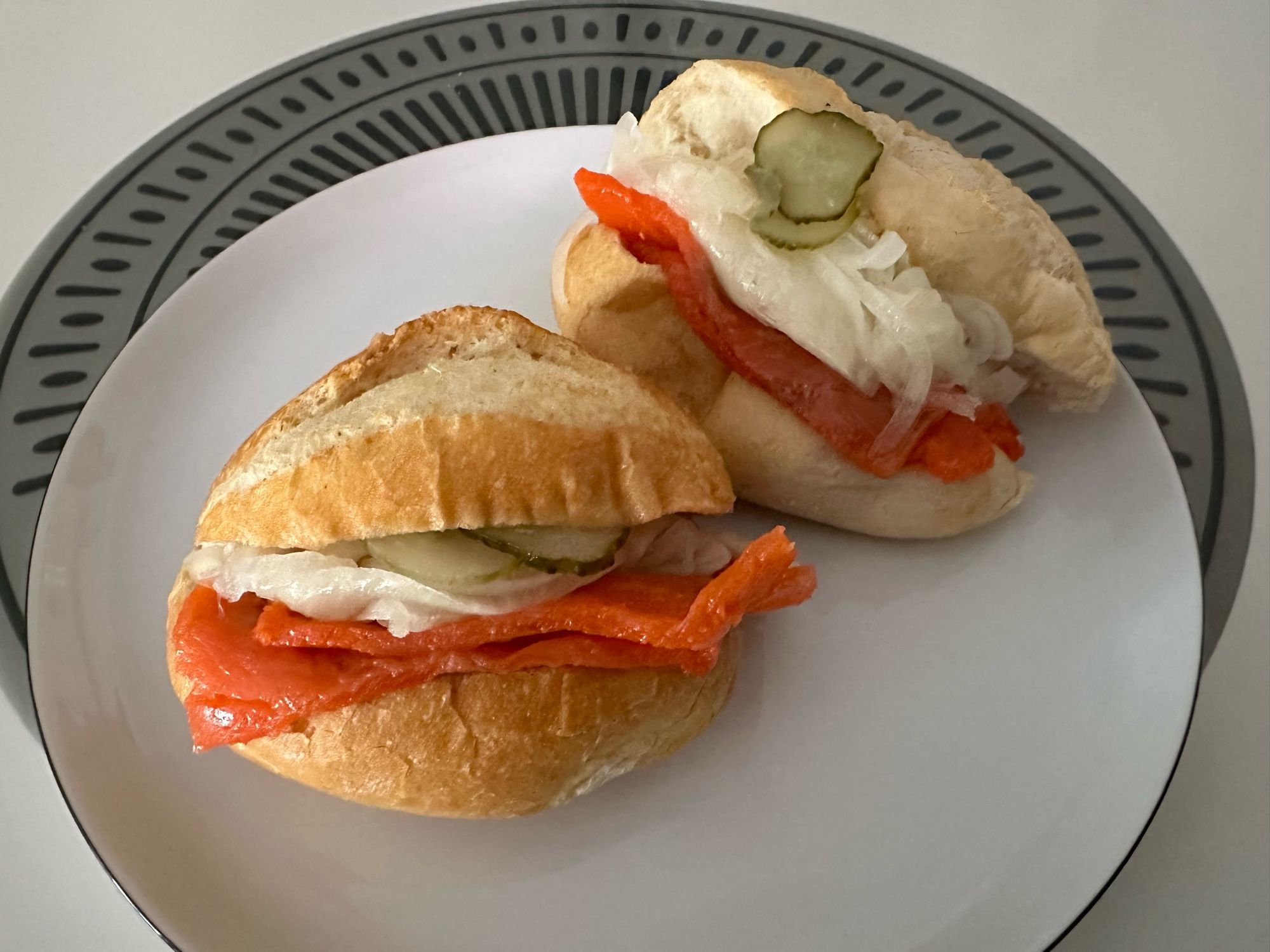 Zwei Lachsbrötchen mit übertrieben vielen Zwiebeln.