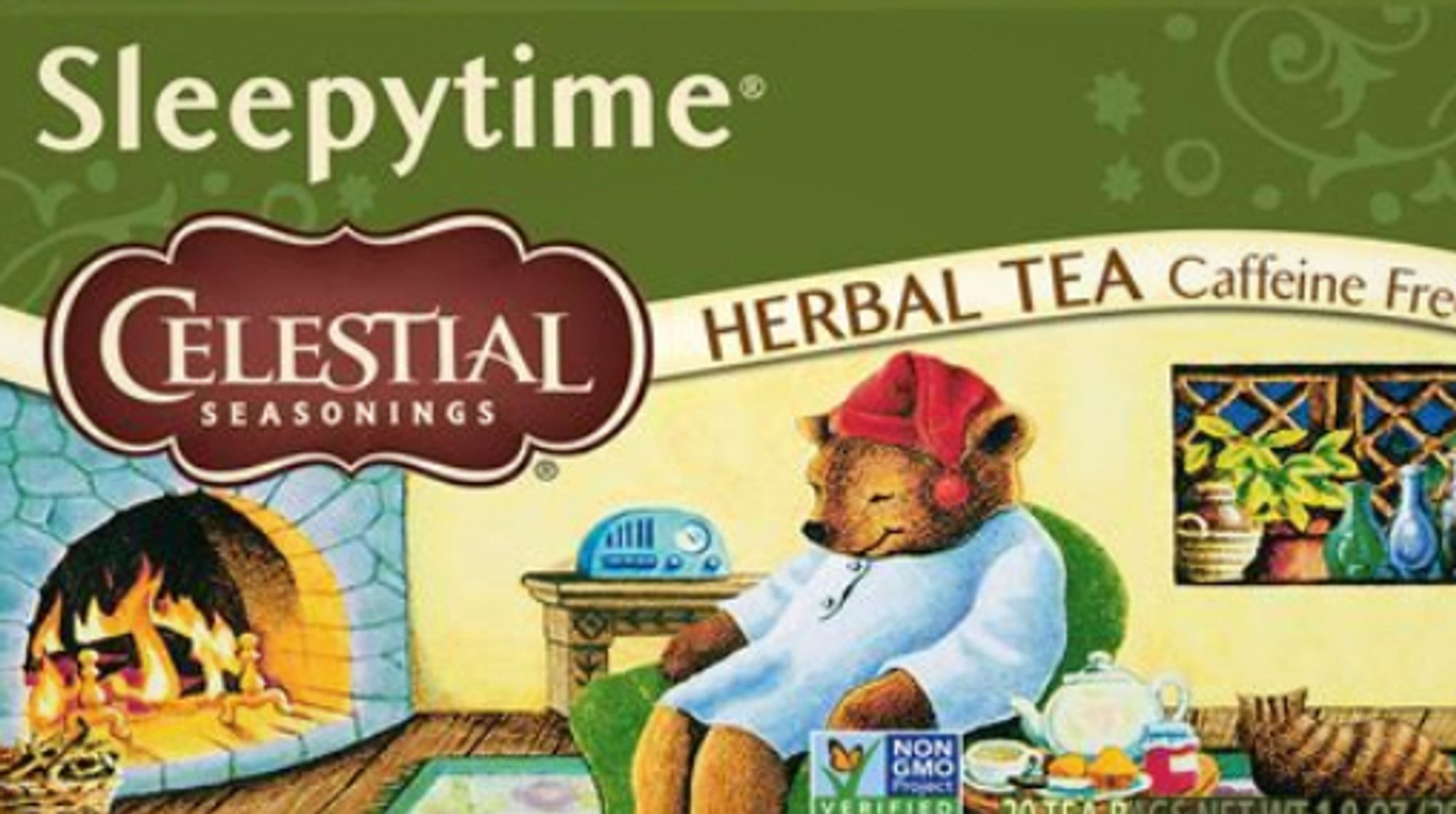 the front of a box of sleepytime tea, that shows a bear sleeping by a fireplace, wearing a red nightcap