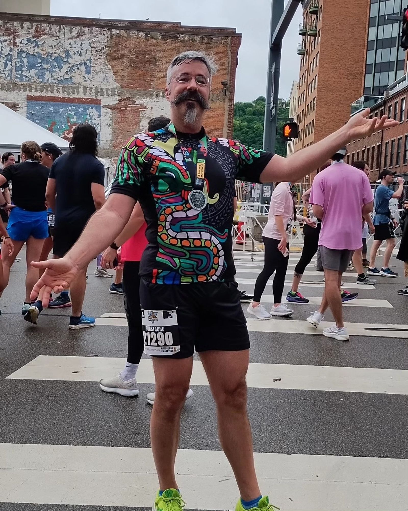 Tom smiles, arms wide, at the end of the Pittsburgh Marathon.