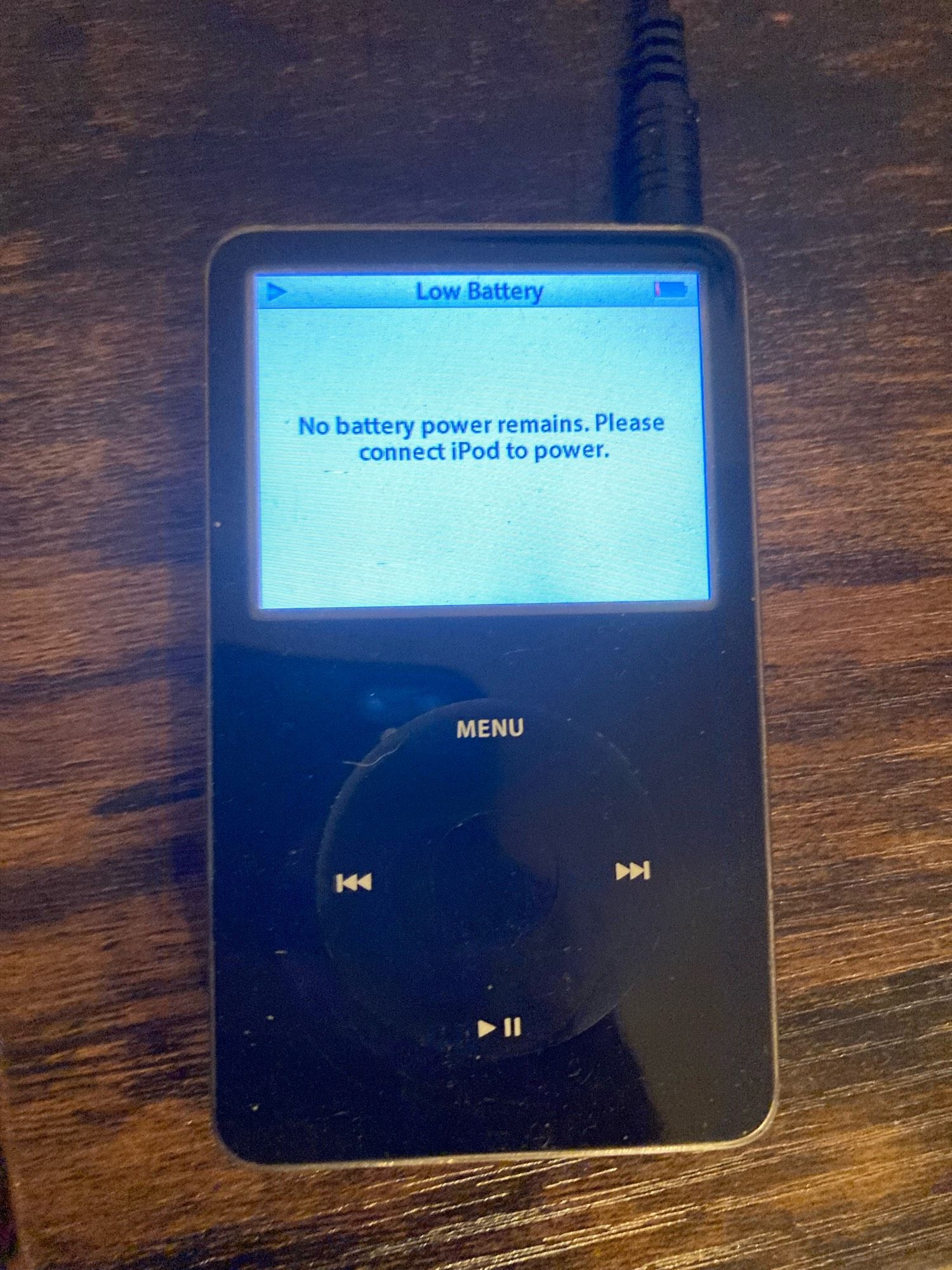 An iPod displaying “No battery power remains. Please connect iPod to power.”