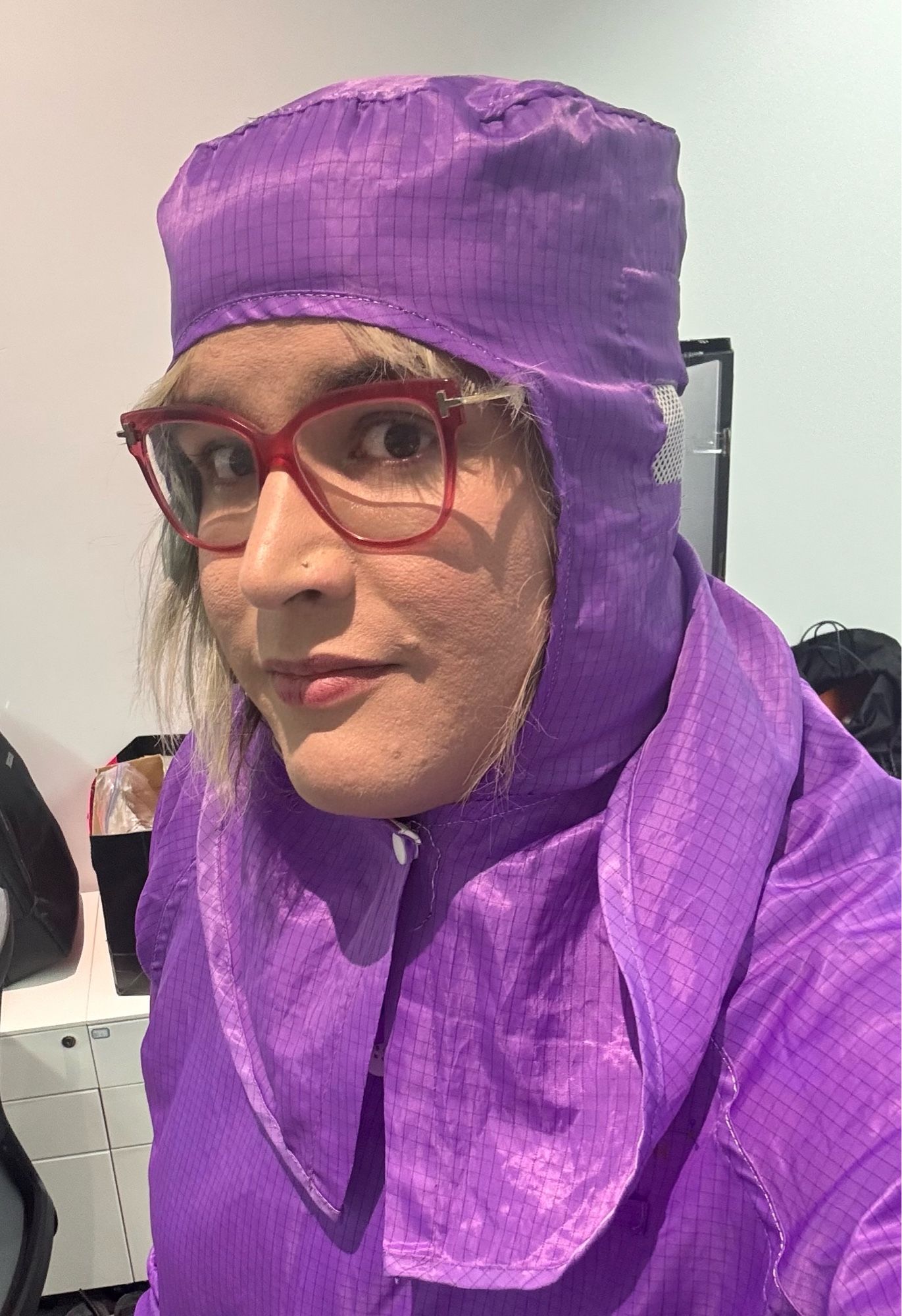 Juniper is a white woman in a purple jacket and head covering that is anti-static safe for working on electronics