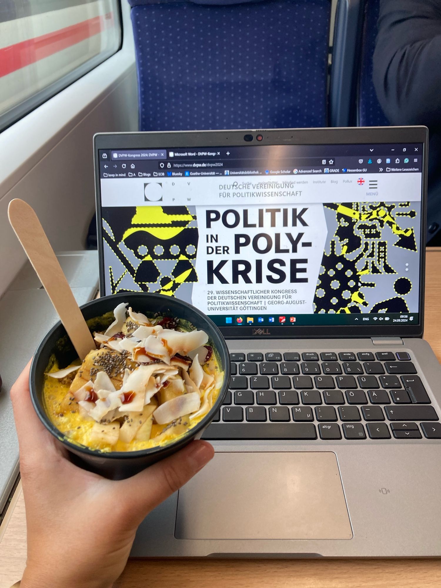 Laptop and a hand holding porridge