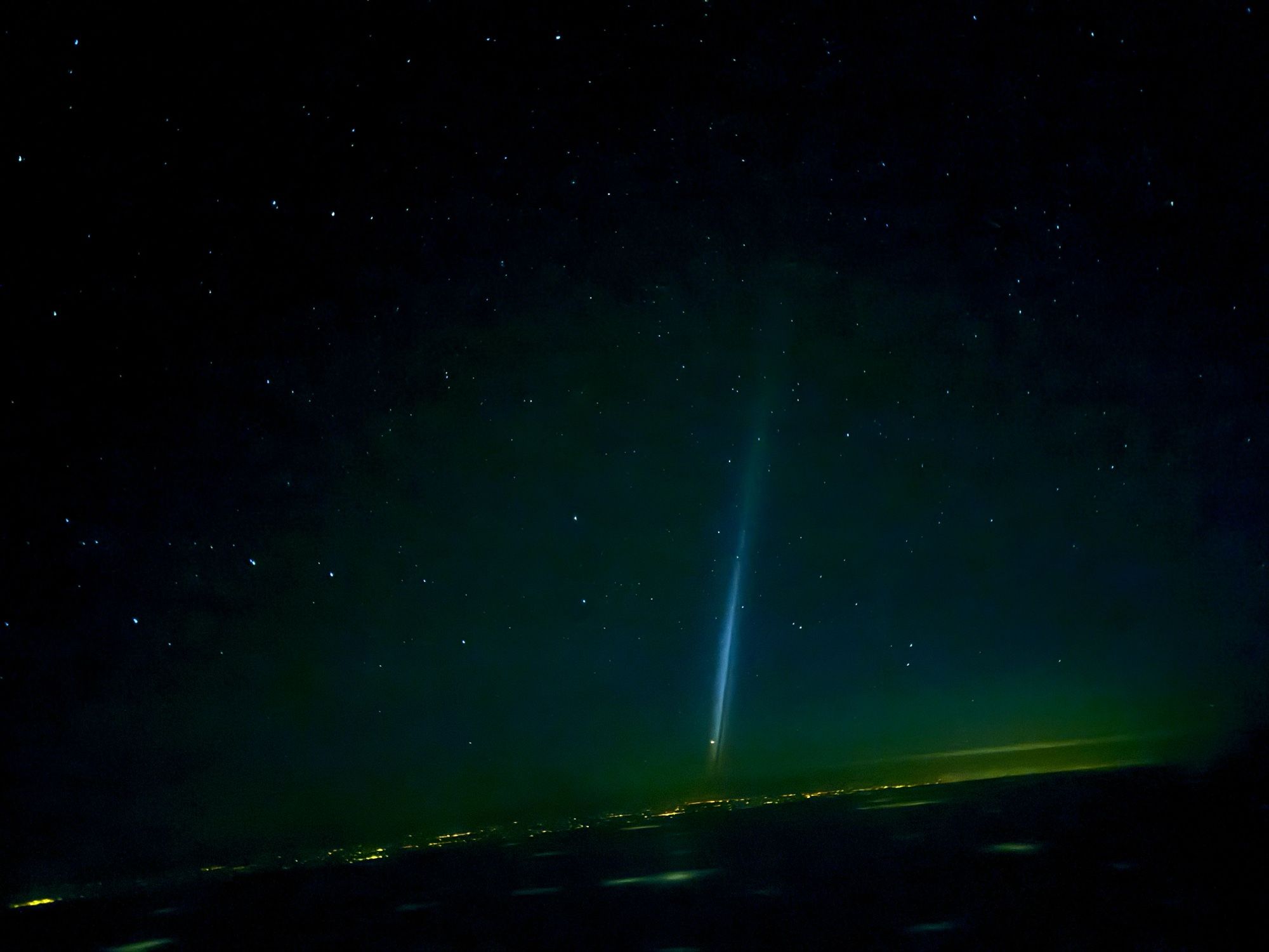 Near-vertical column of light in a starry sky.