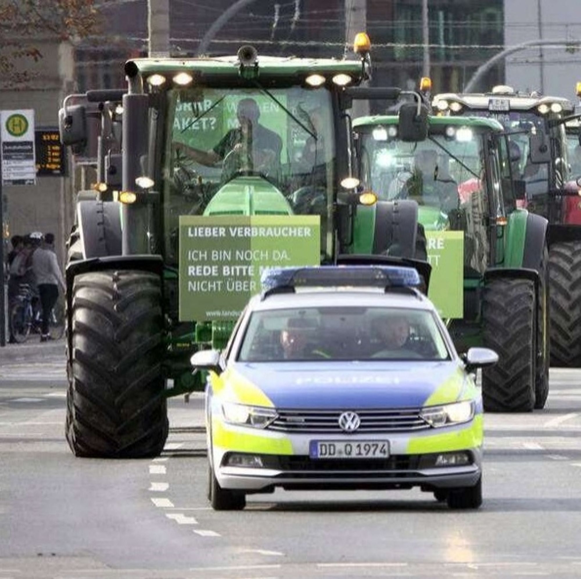 Eine Bauern-Demo: ein Traktoren-Konvoi wird angeführt von einem Polizeiwagen