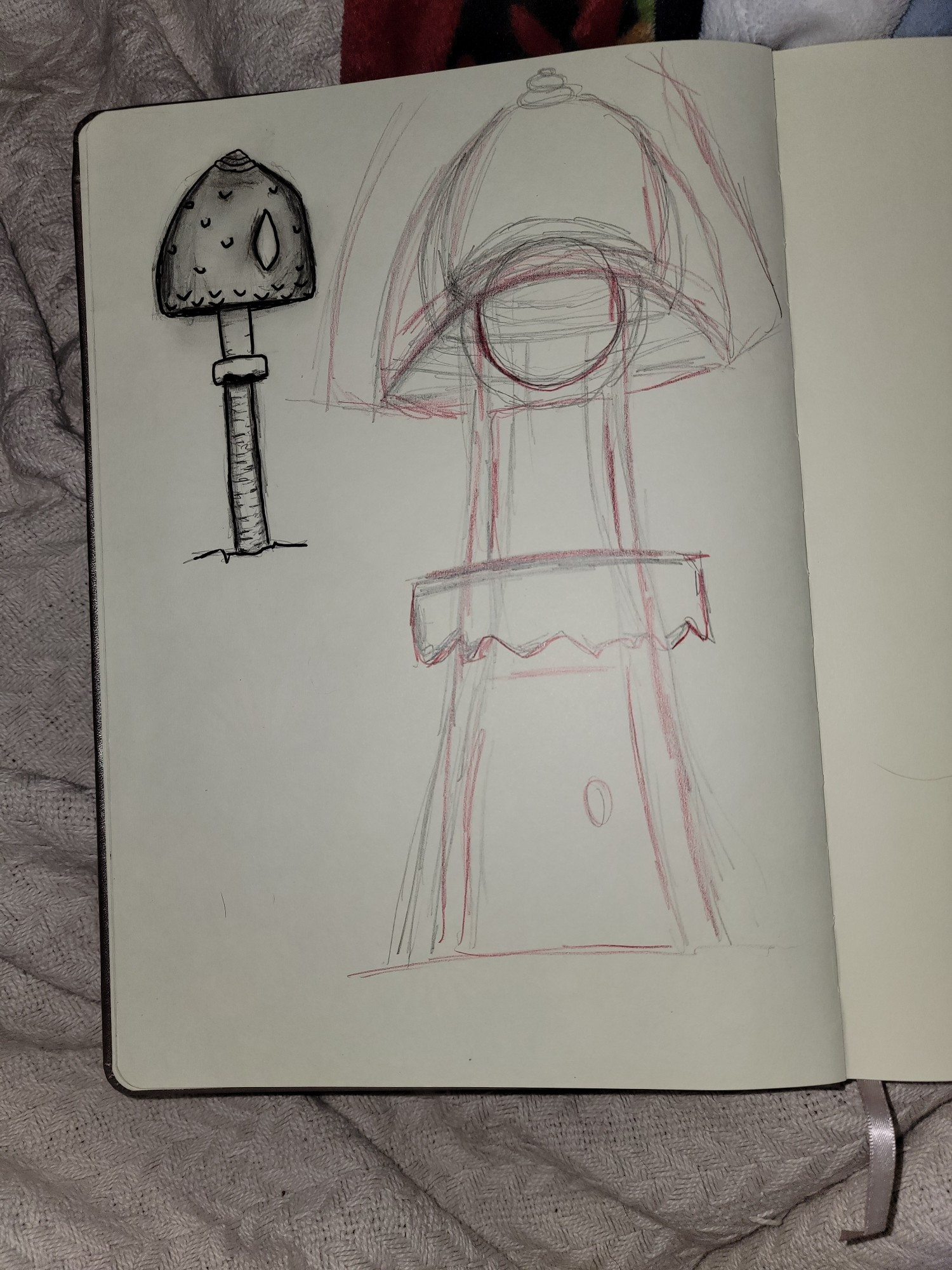 The image depicts two sketches of parasol mushrooms. The smaller one on the left takes up about one fourth the page and is very well defined. The larger one on the right is more sketchy and not finished. It takes up a little over half the page. Underneath the mushroom cap there is a circle and there is a door at the bottom of the stalk.