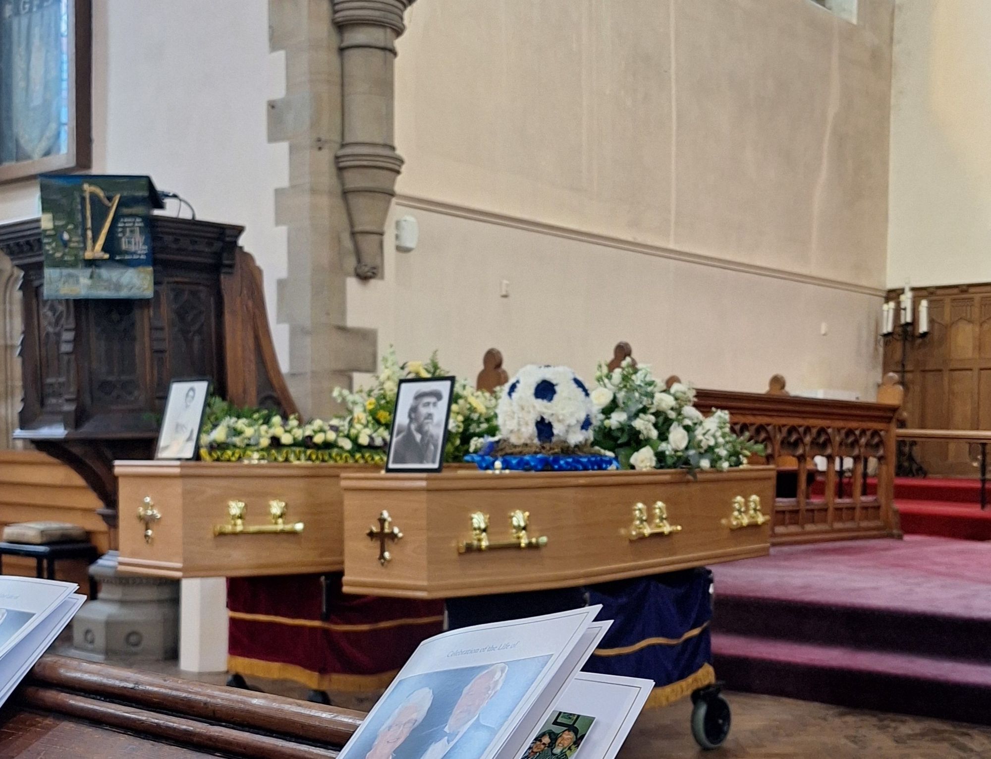 Two coffins side by side at the front of a church, decorated with flowers in the shape of a heart on my grandmother's and in the shape of a football on my grandfather's, with framed photos of them on top of each