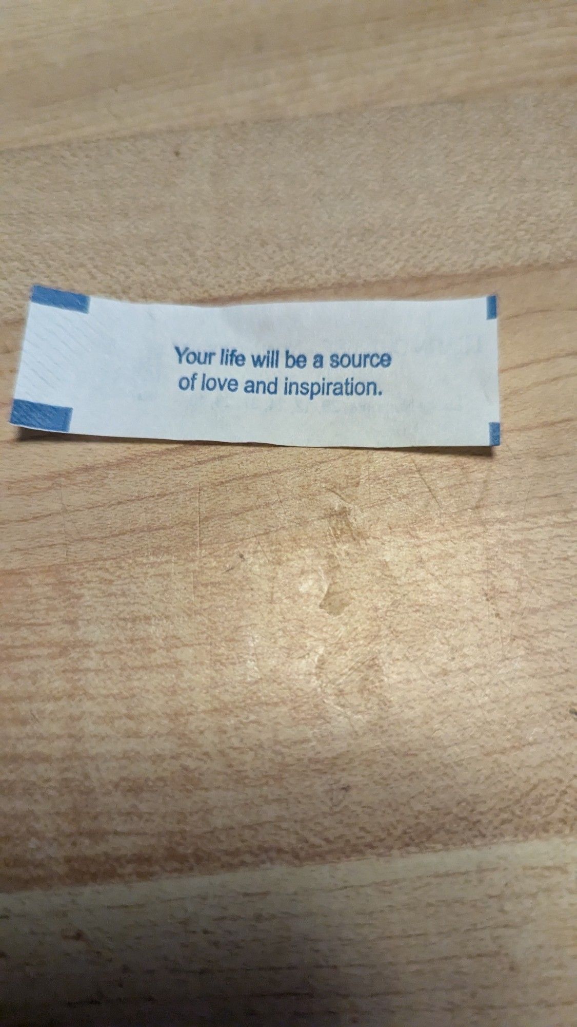 A note from a fortune cookie stating "your life will be a source of love and inspiration"