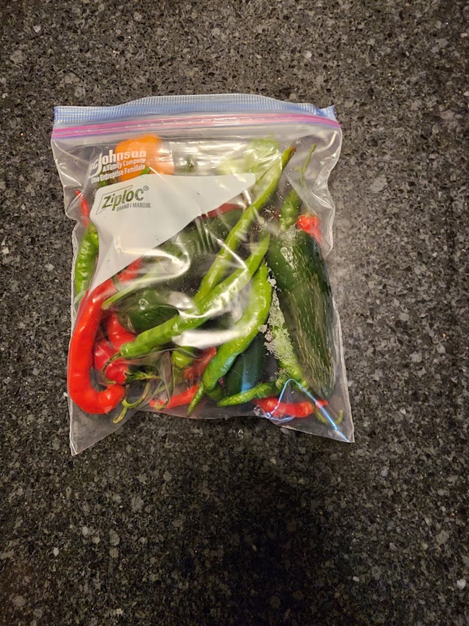 A multicolour bag of peppers in a zip lock on a countertop