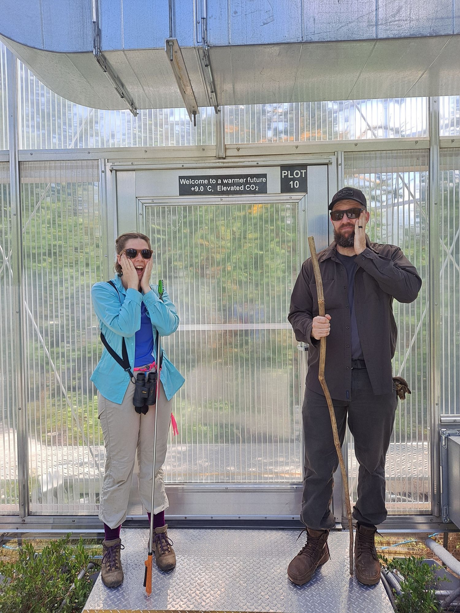 People in front of a door that says, "welcome to a warmer future. +9°C, elevated CO2."